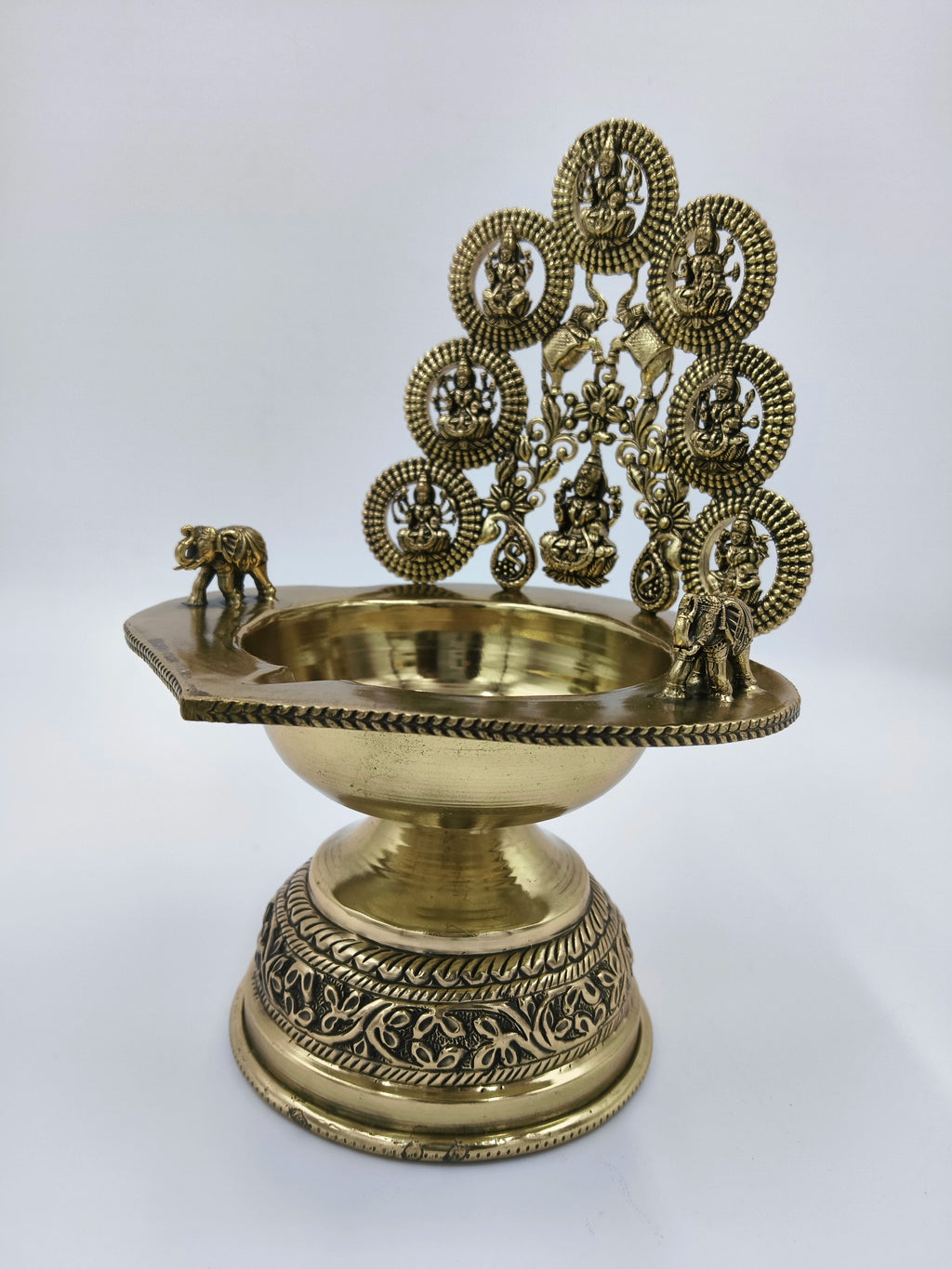 brass Astalakshmi lamp with detailed deity figures and elephant accents