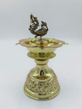 Large brass diya oil lamp with detailed peacock figure and engraved base