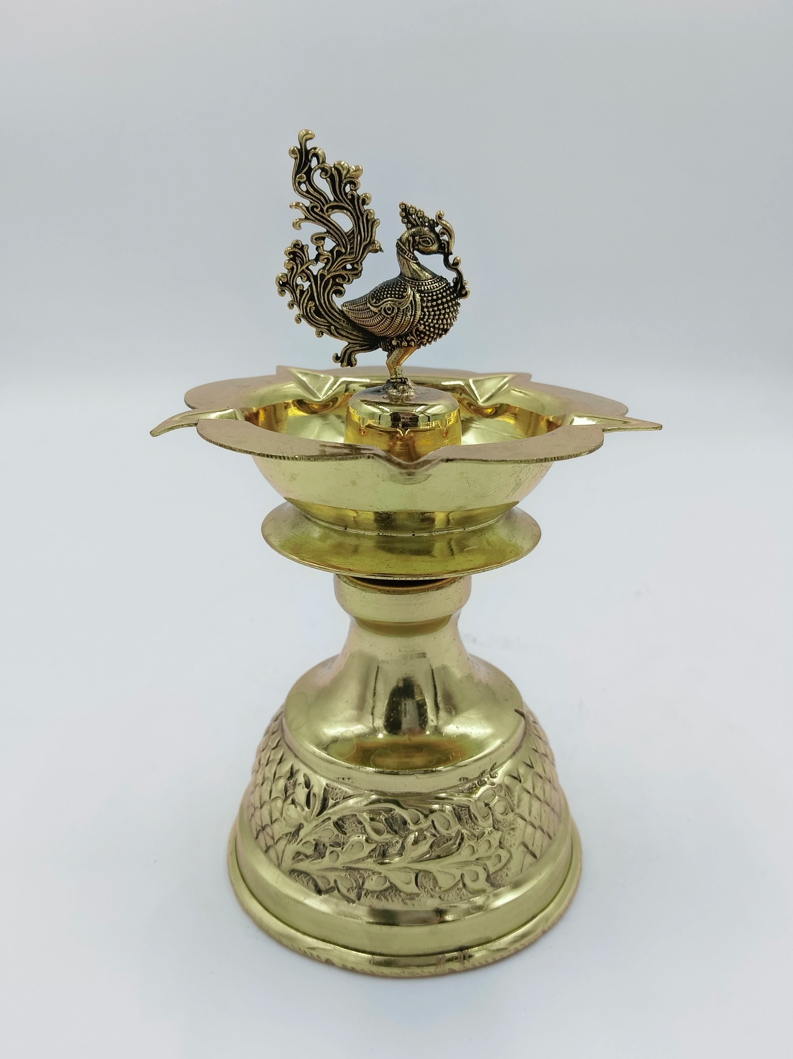 Large brass diya oil lamp with detailed peacock figure and engraved base