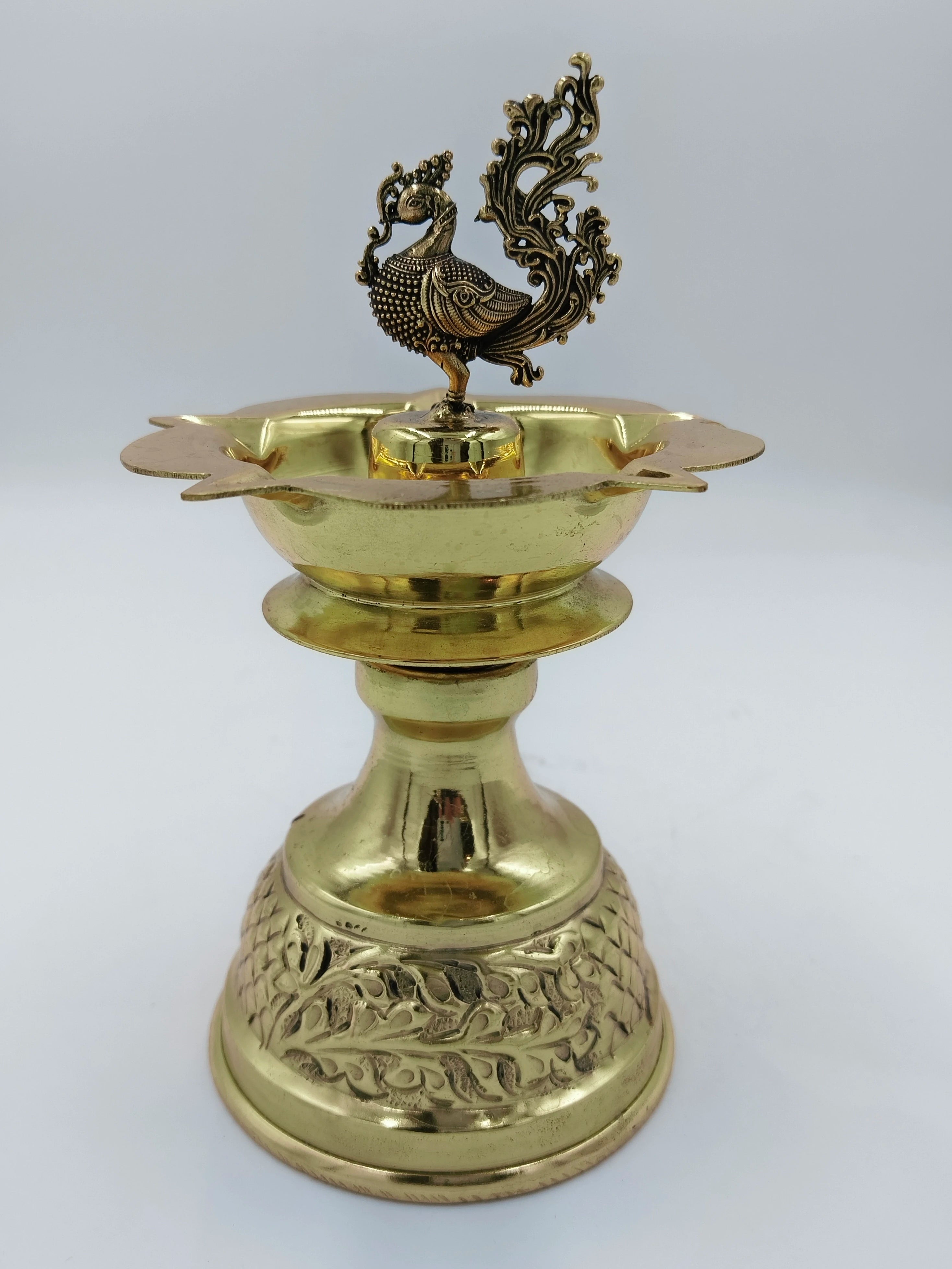 Large brass peacock diya oil lamp with ornate base and detailed peacock figure