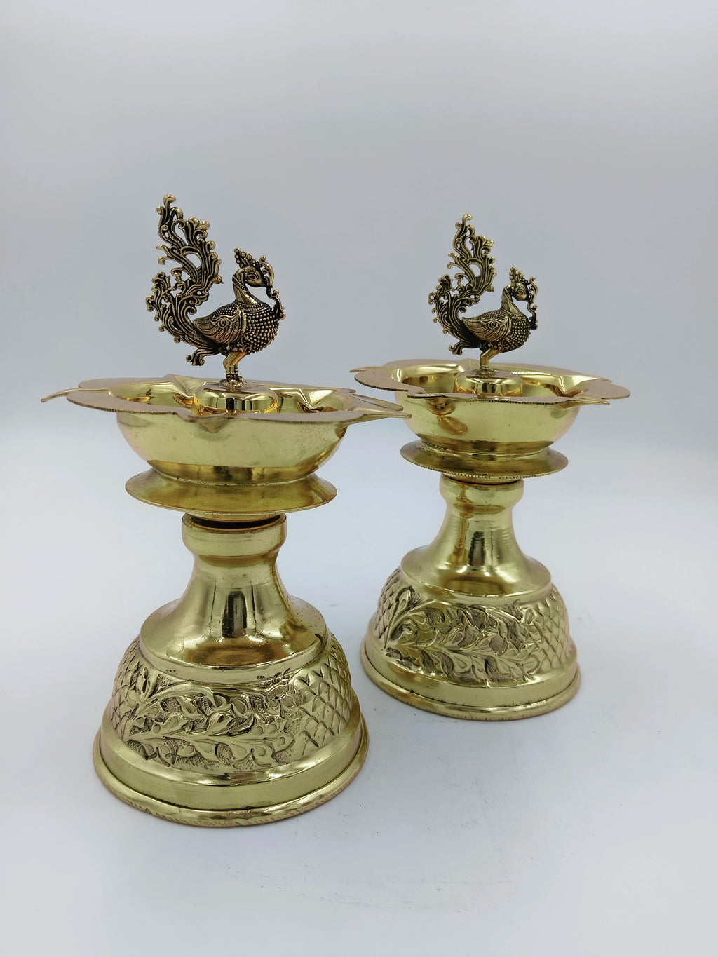 Pair of large brass peacock diya oil lamps with detailed engraved bases