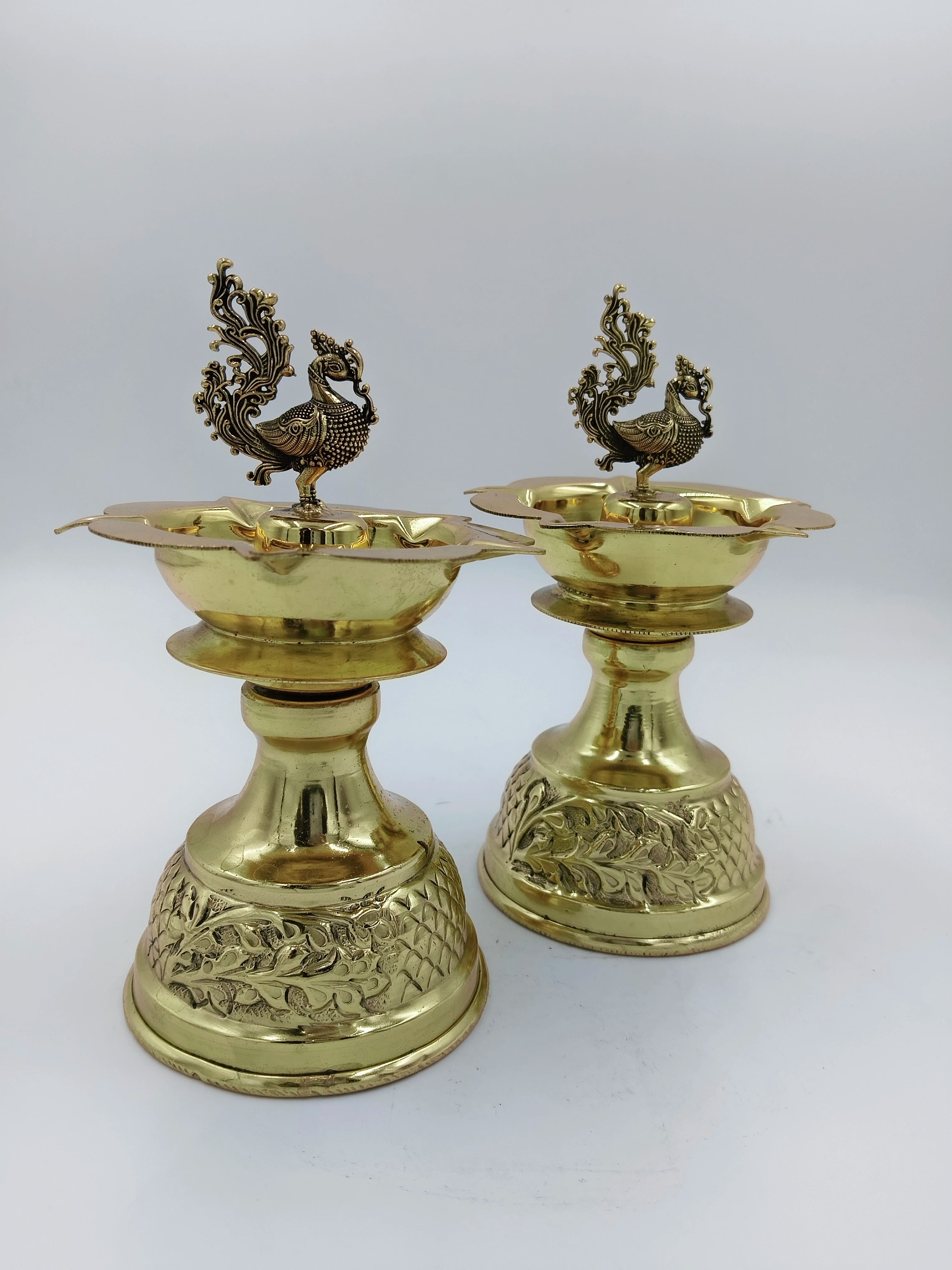 Pair of large brass peacock diya oil lamps with detailed engraved bases