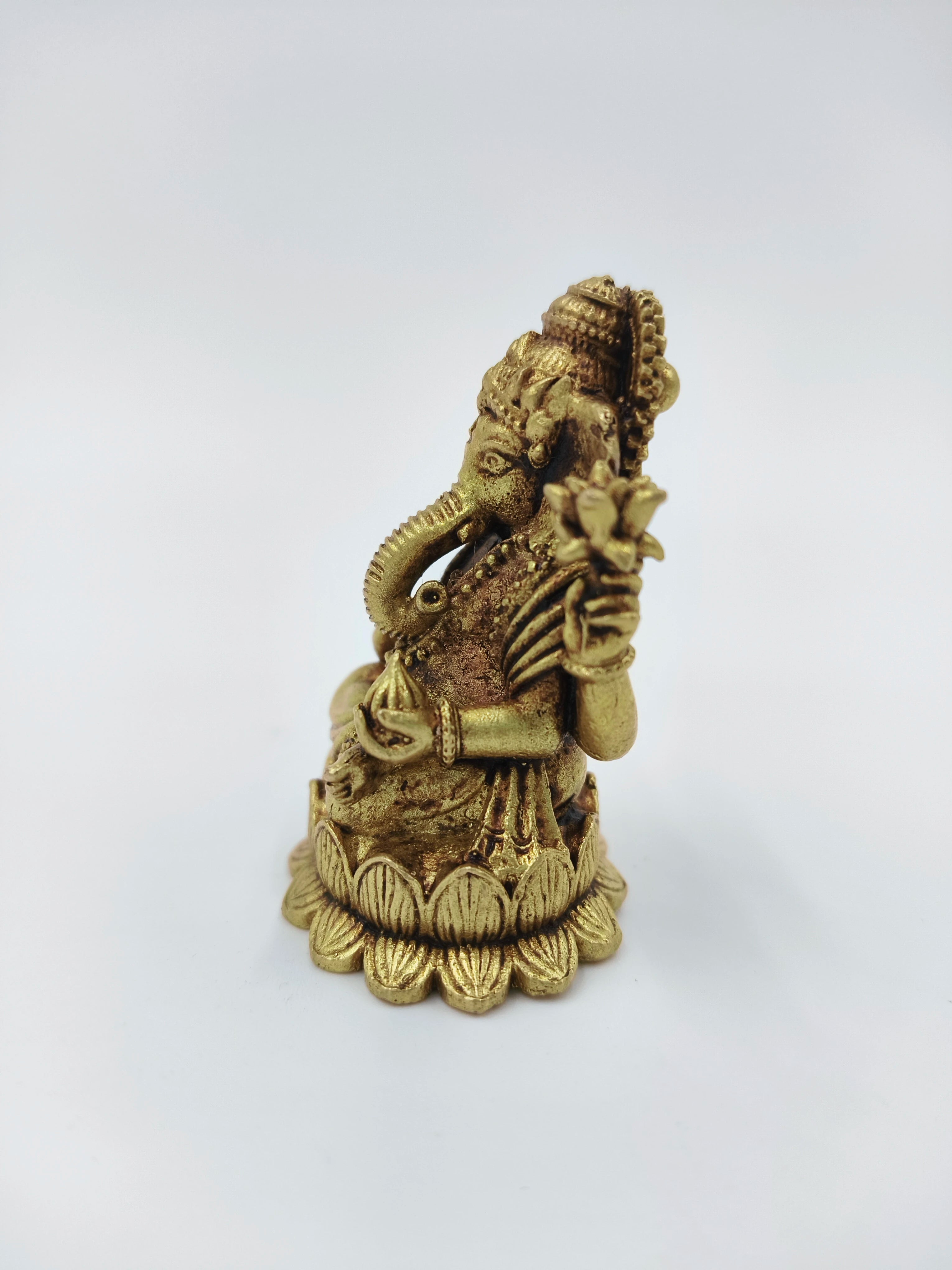 Mini brass Ganesh idol sitting on lotus base side view