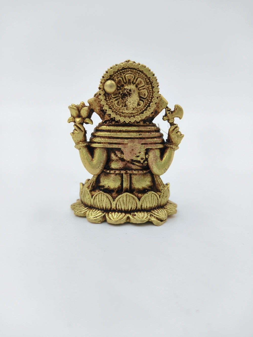 Back view of mini brass Ganesh idol seated on a lotus base