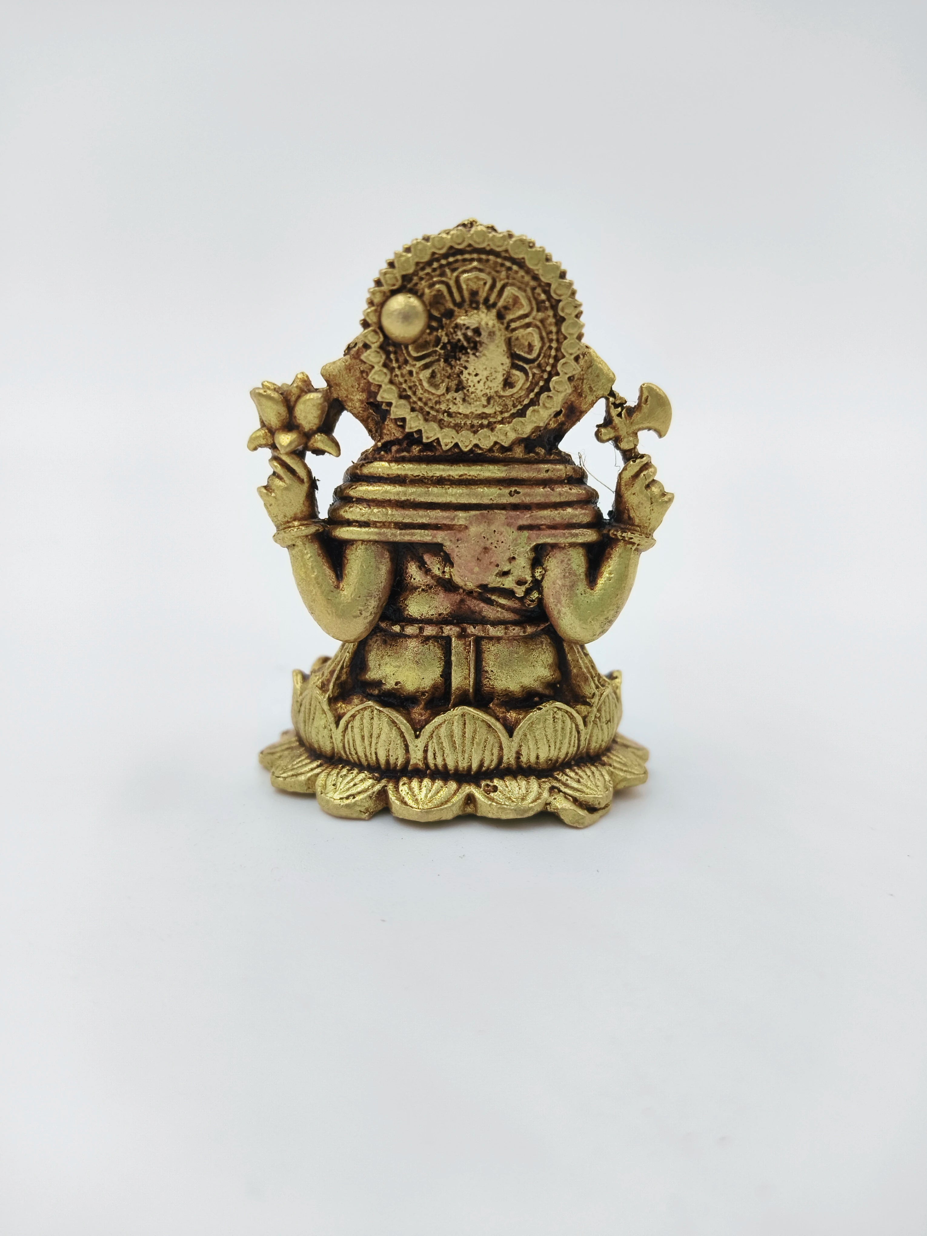 Back view of mini brass Ganesh idol seated on a lotus base