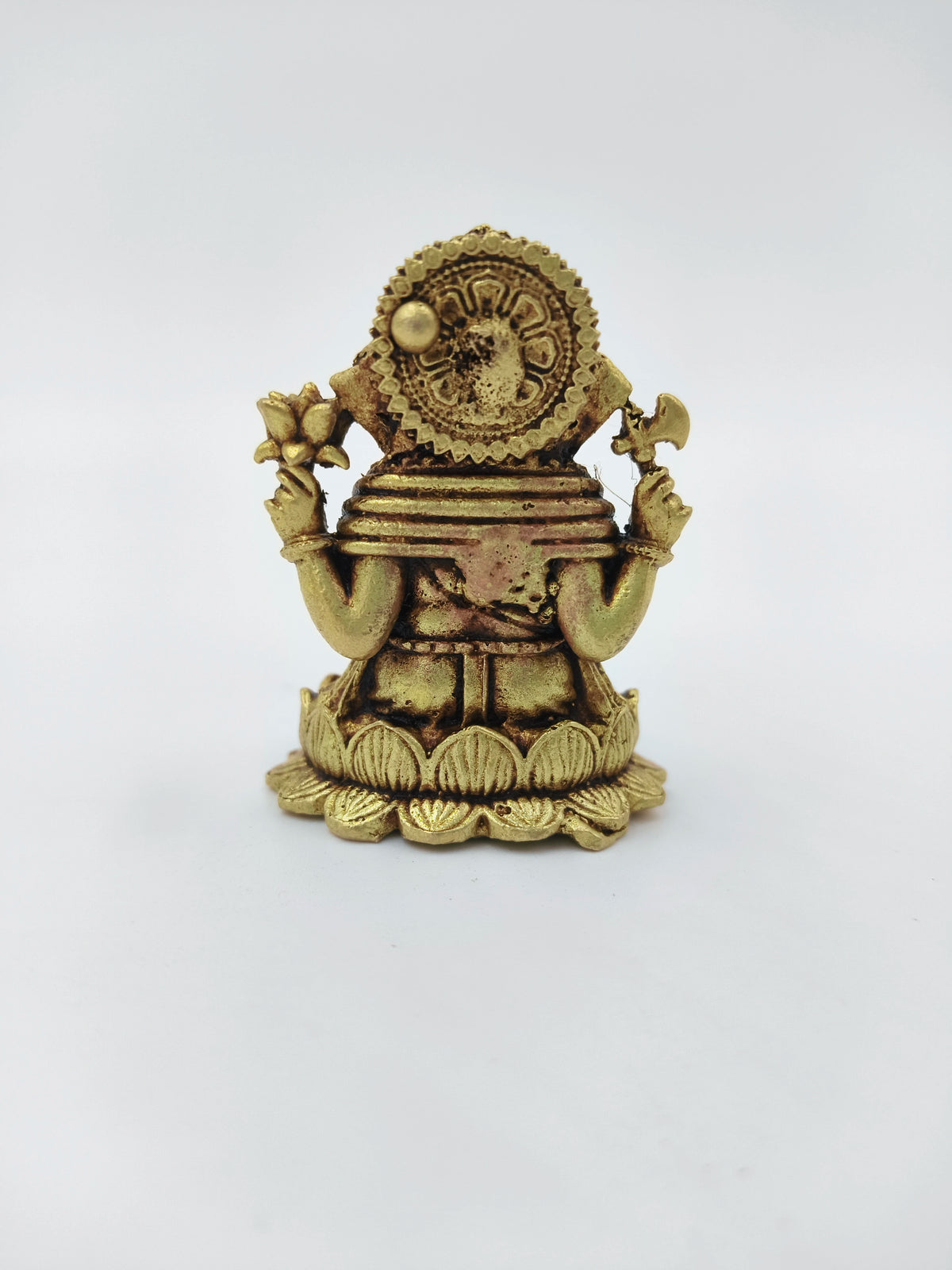 Back view of mini brass Ganesh idol seated on a lotus base