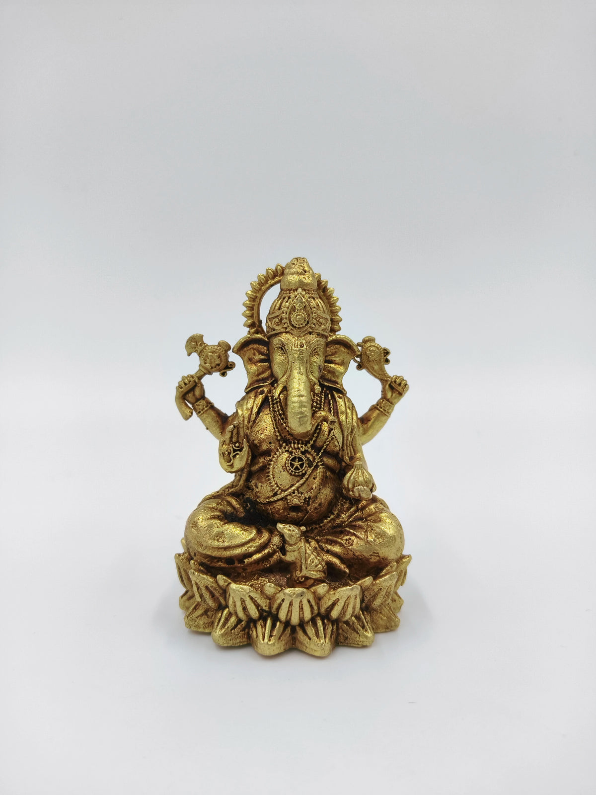 Small brass statue of Vakratunda Ganesh seated on lotus pedestal