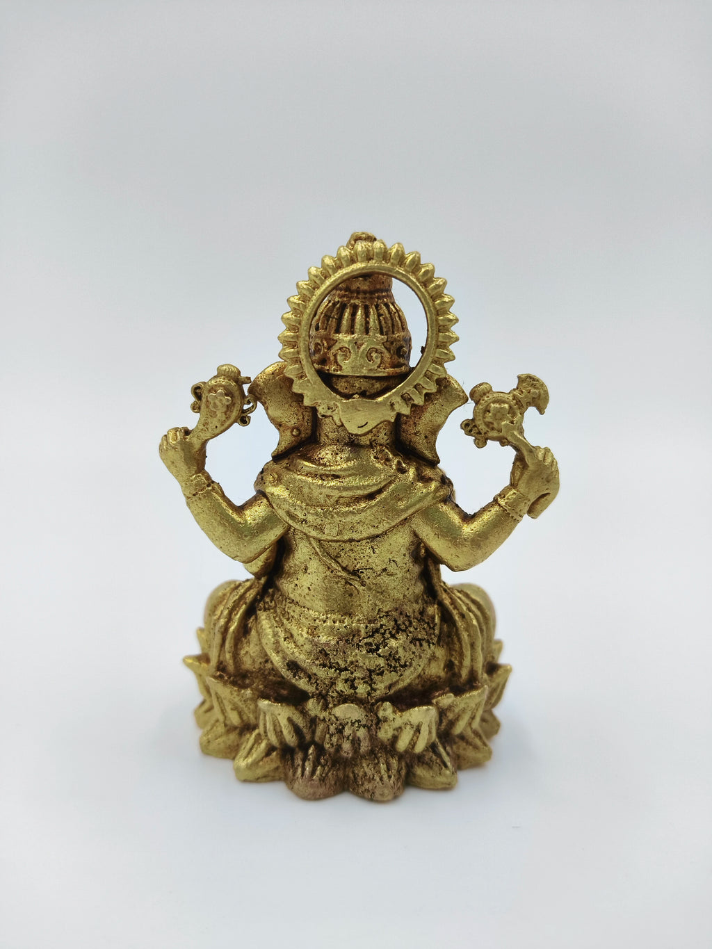 Back view of small brass Vakratunda Ganesh statue seated on lotus
