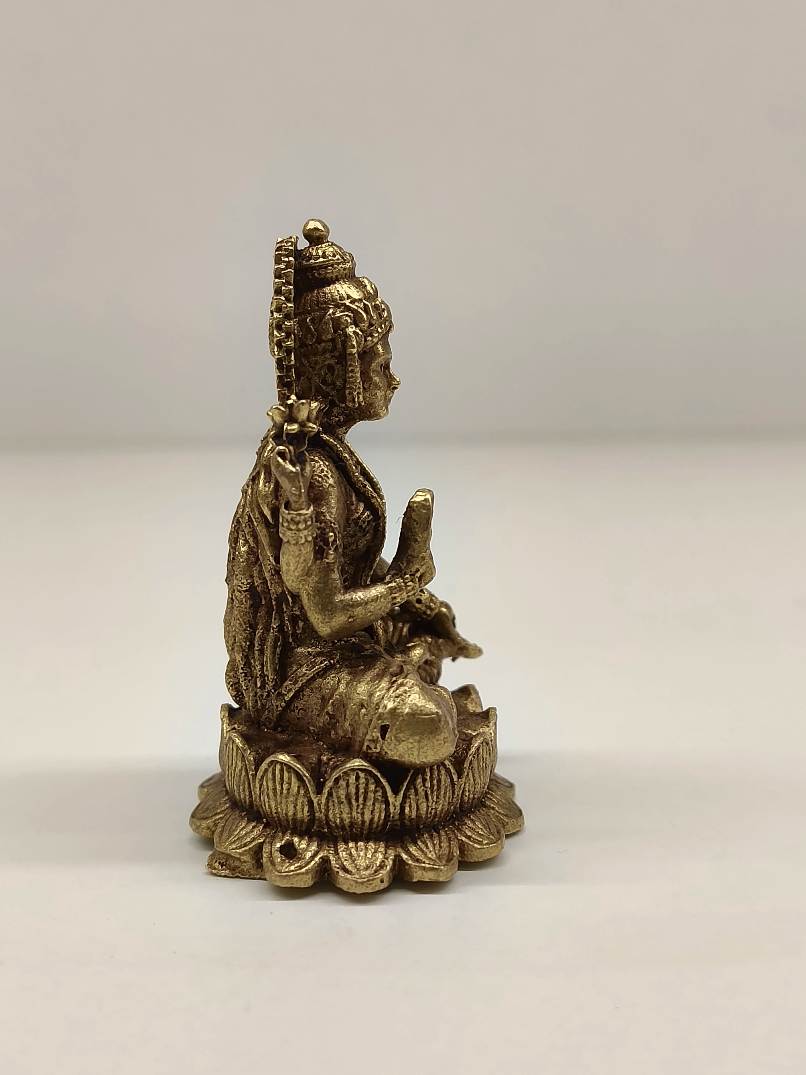 Side view of mini brass Lakshmi idol seated on lotus base
