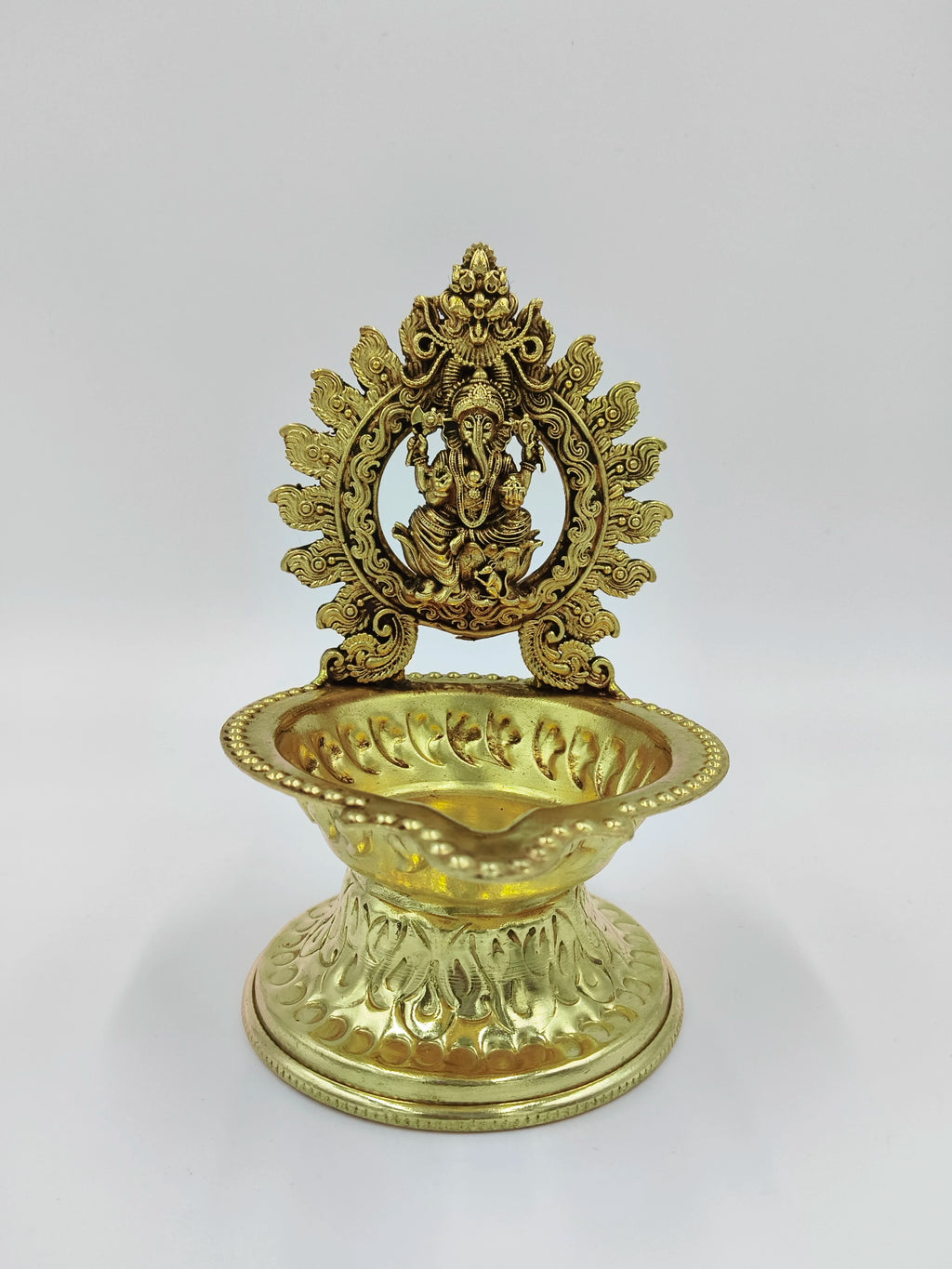 Brass lamp with detailed Ganesh idol and ornate decorative base