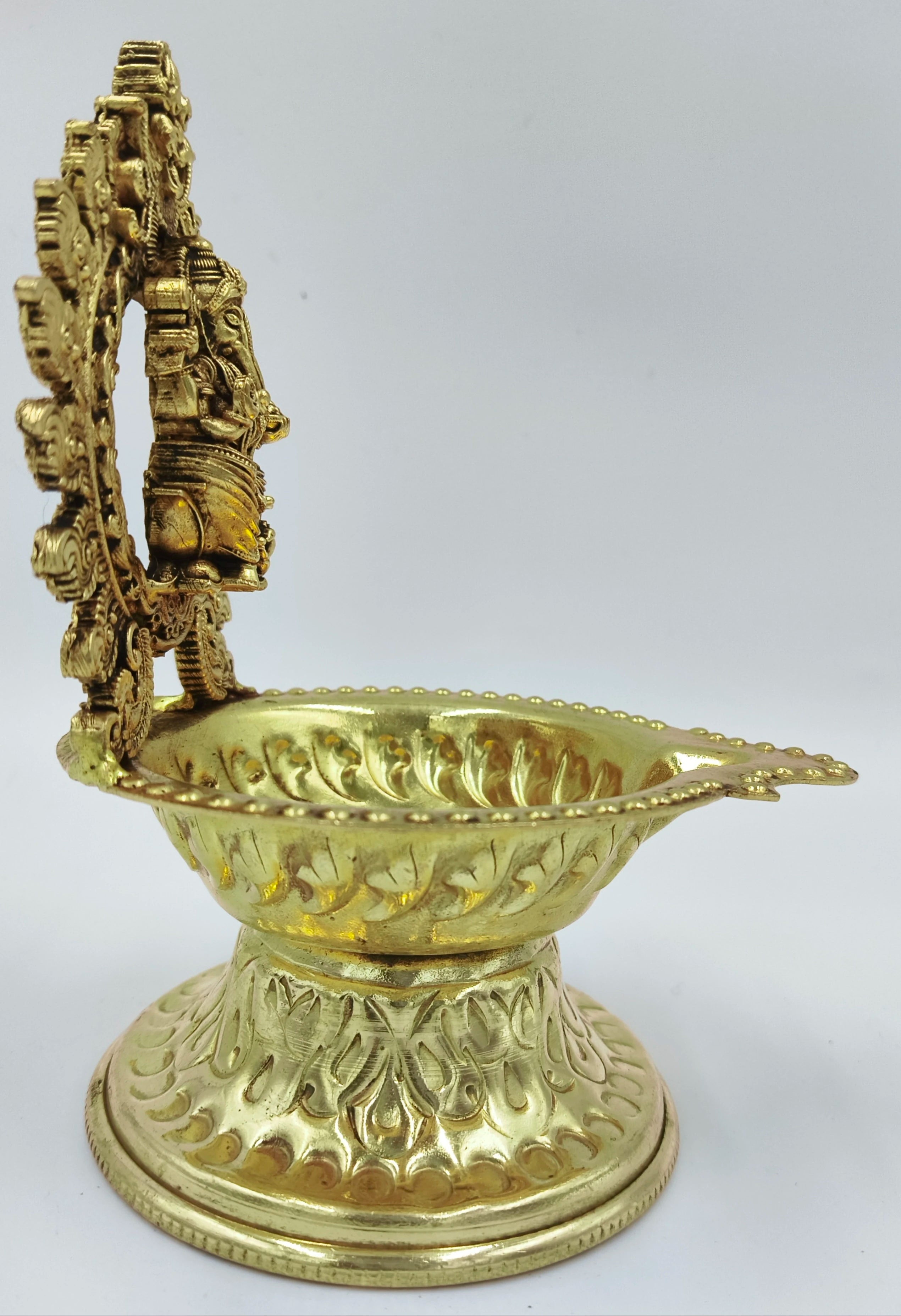 Side view of medium brass lamp with Ganesha figure and decorative patterns