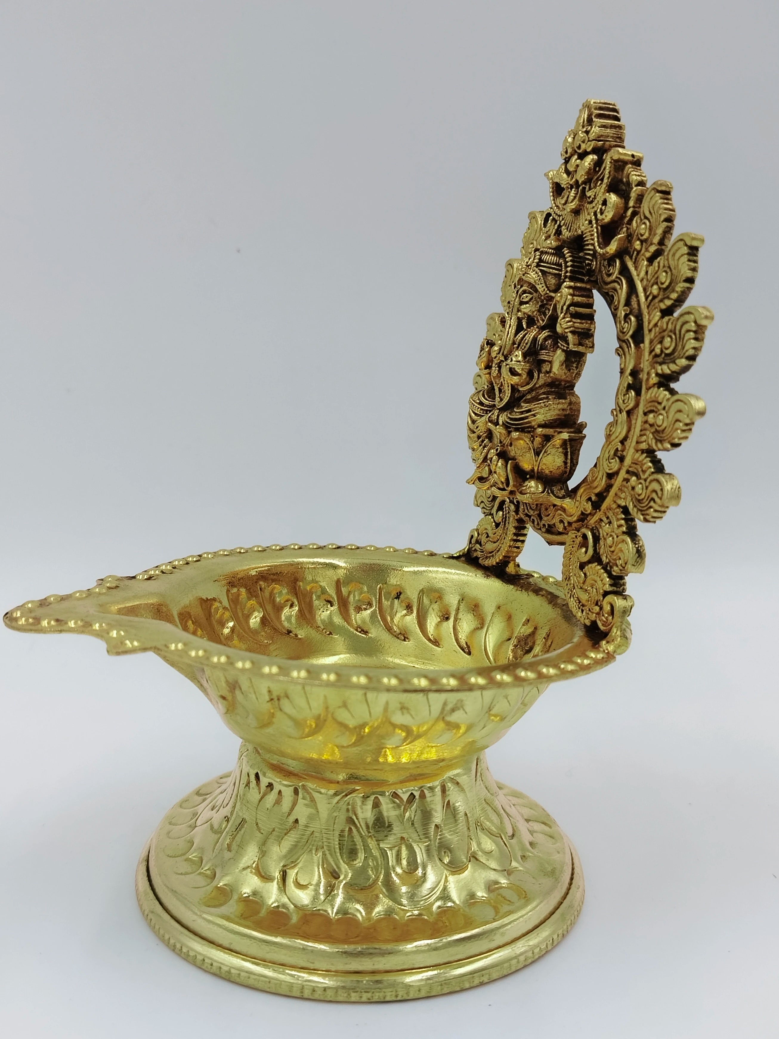 Medium brass lamp with ornate base and detailed Ganesh figure on back