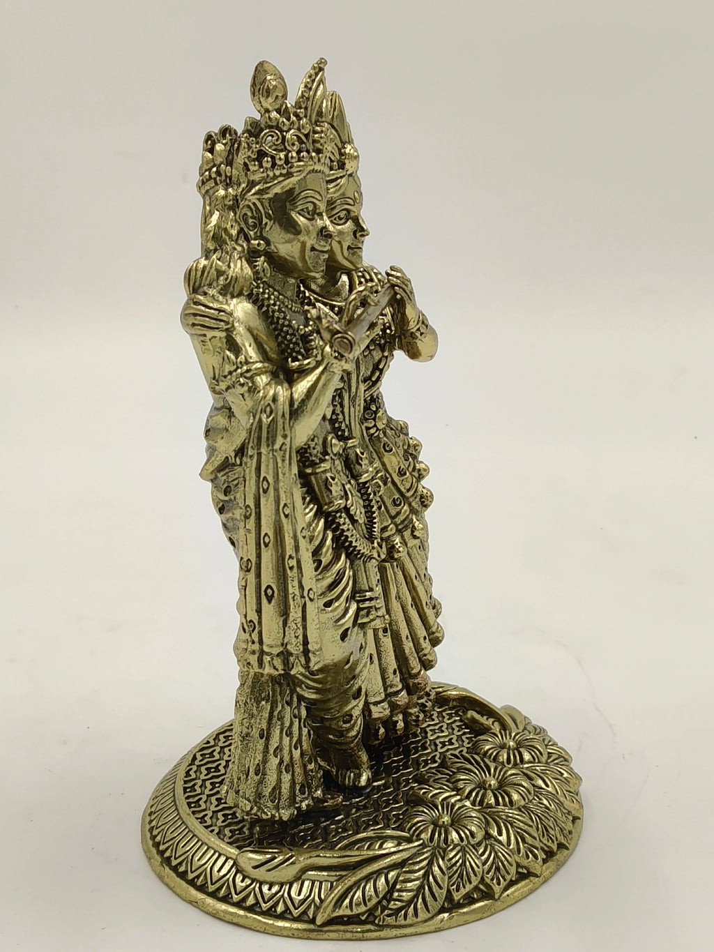 Brass statue of Radhakrishna on decorative base, side view