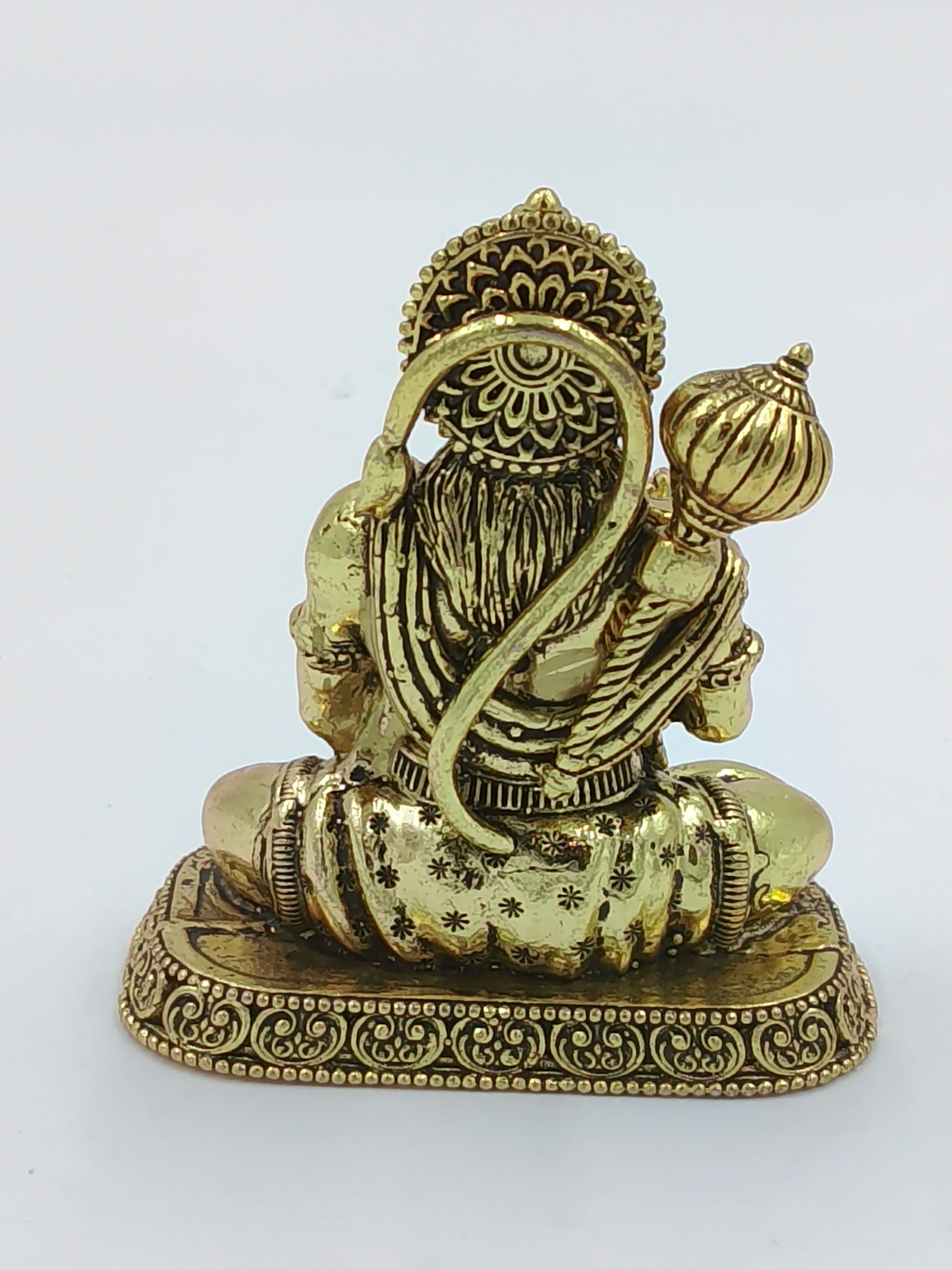 Back view of small brass Hanuman statue seated on decorated base
