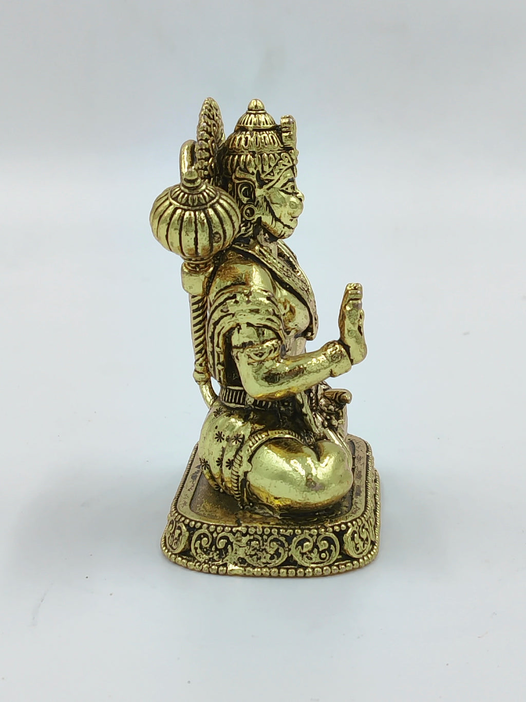 Small brass Hanuman statue seated in meditation with mace on back side view