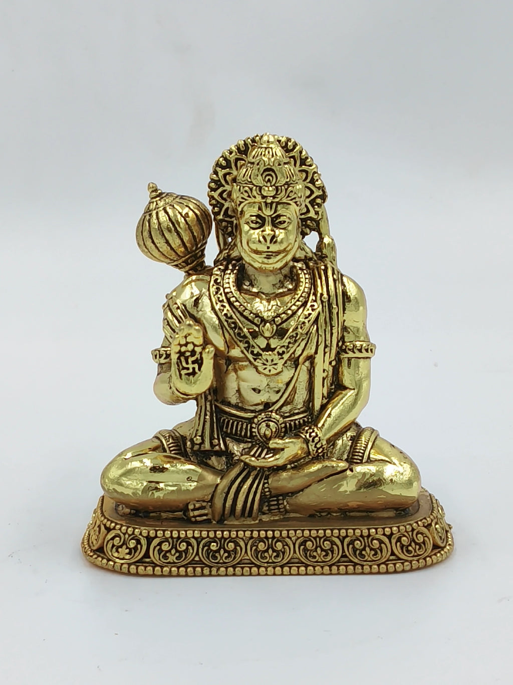 Small brass Hanuman statue seated with raised hand and mace on pedestal
