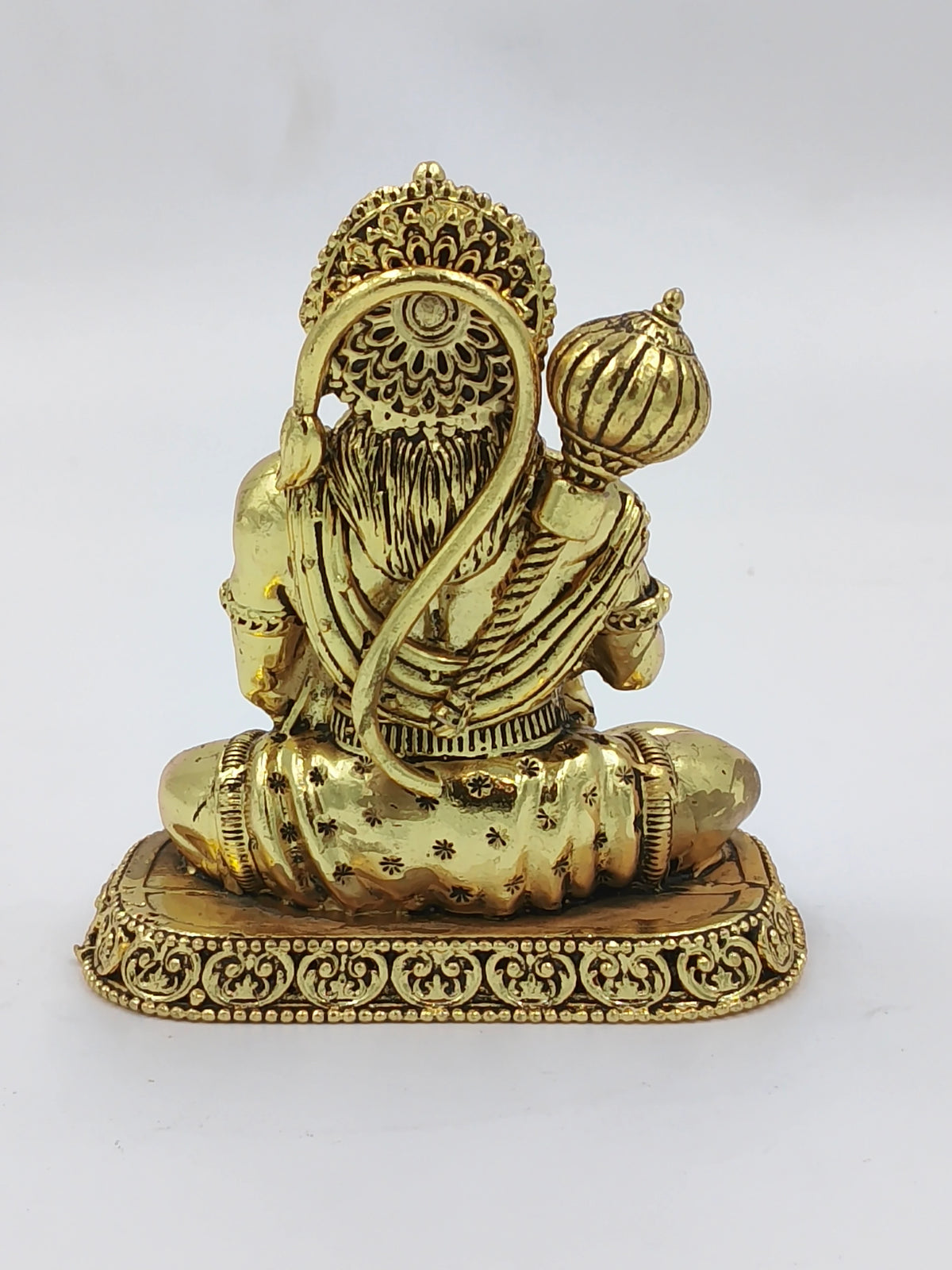 Small brass Hanuman sculpture shown from the back, seated on ornate base