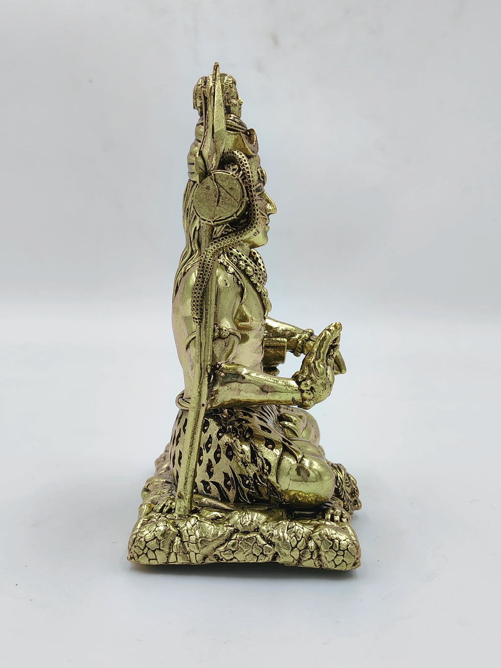 Side view of medium brass Sadashiva statue seated on textured base