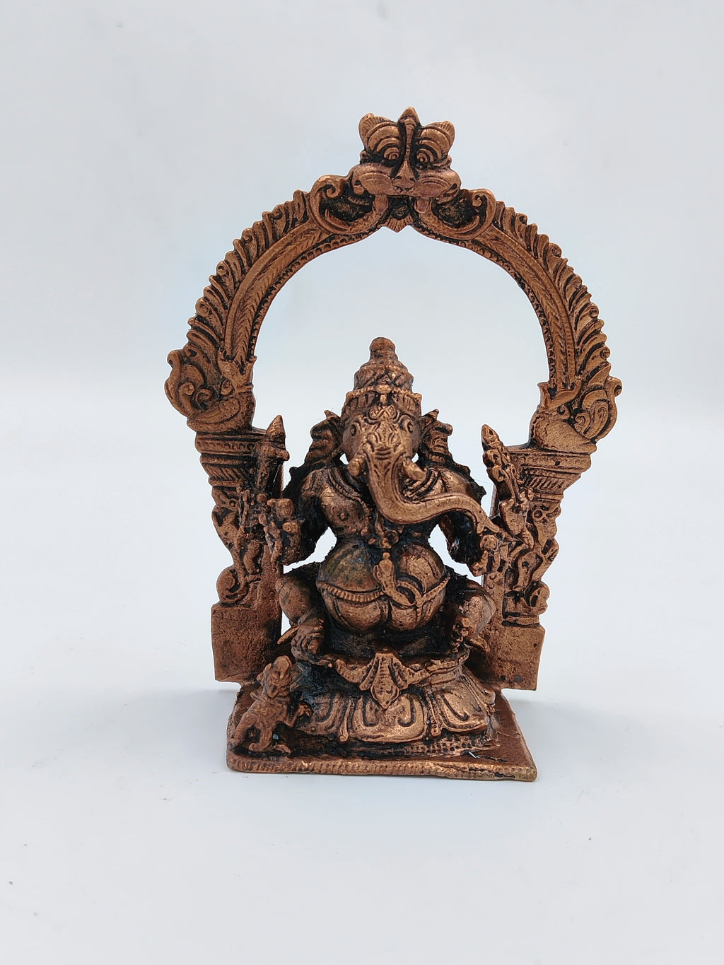 Small brass Ganesh statue with ornate arch frame, front view