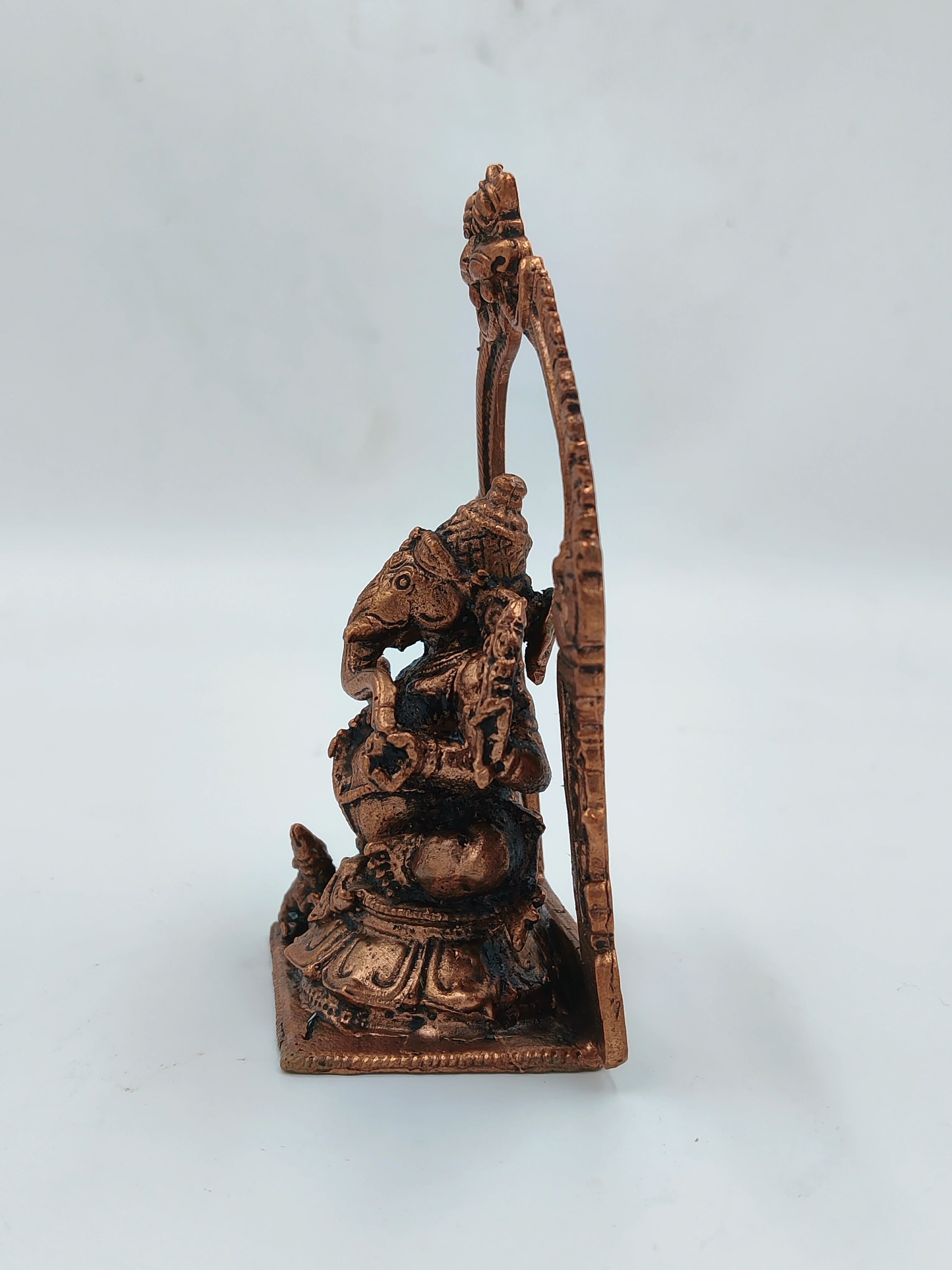 Side view of small brass Ganesh statue with detailed carvings