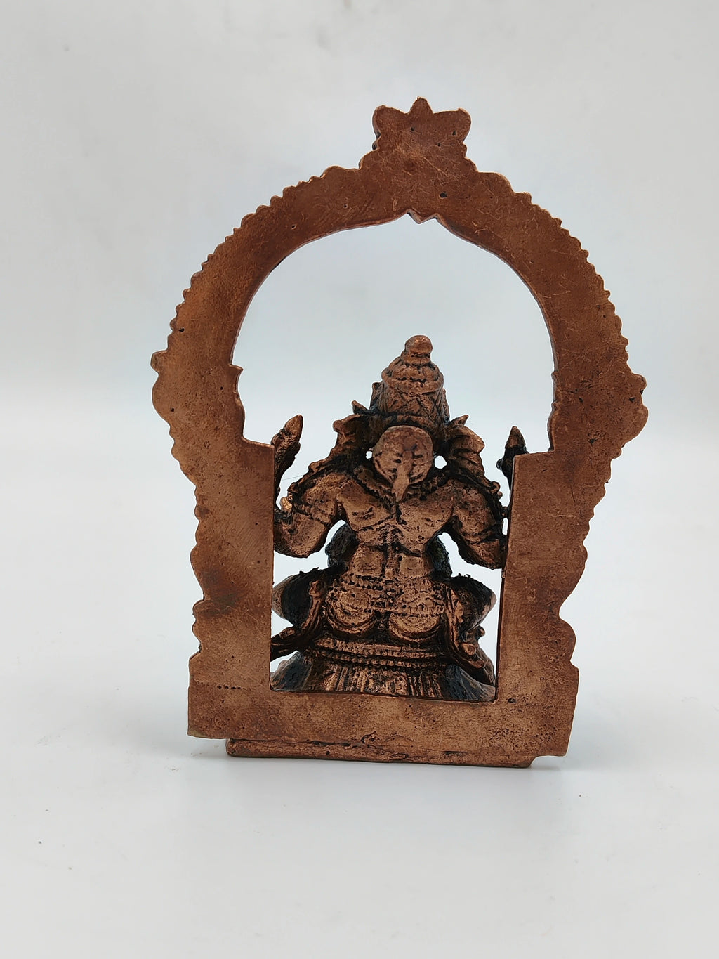 Small brass Ganesh statue with decorative arch frame back view