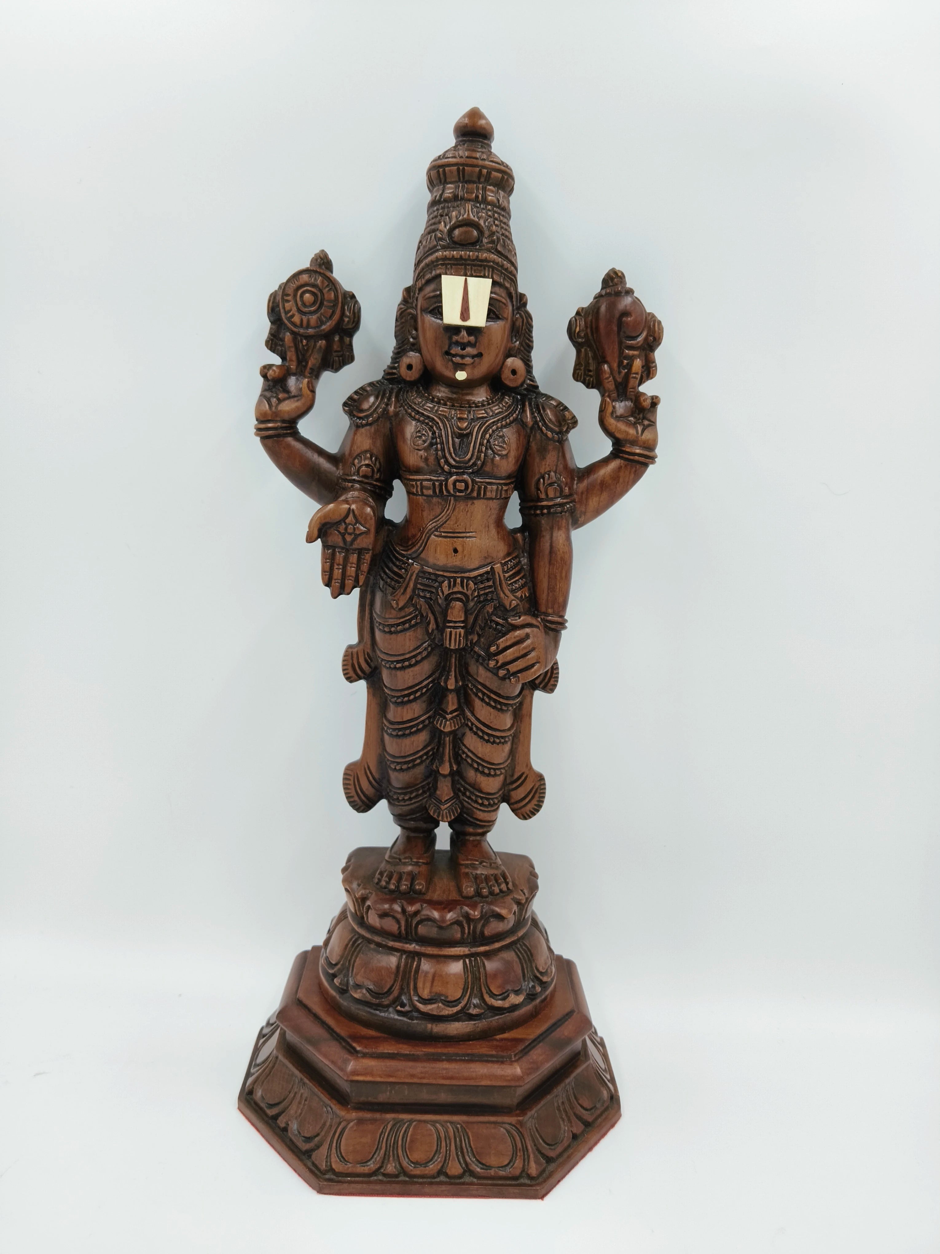 Large teakwood statue of deity Balaji with intricate carvings on ornate base