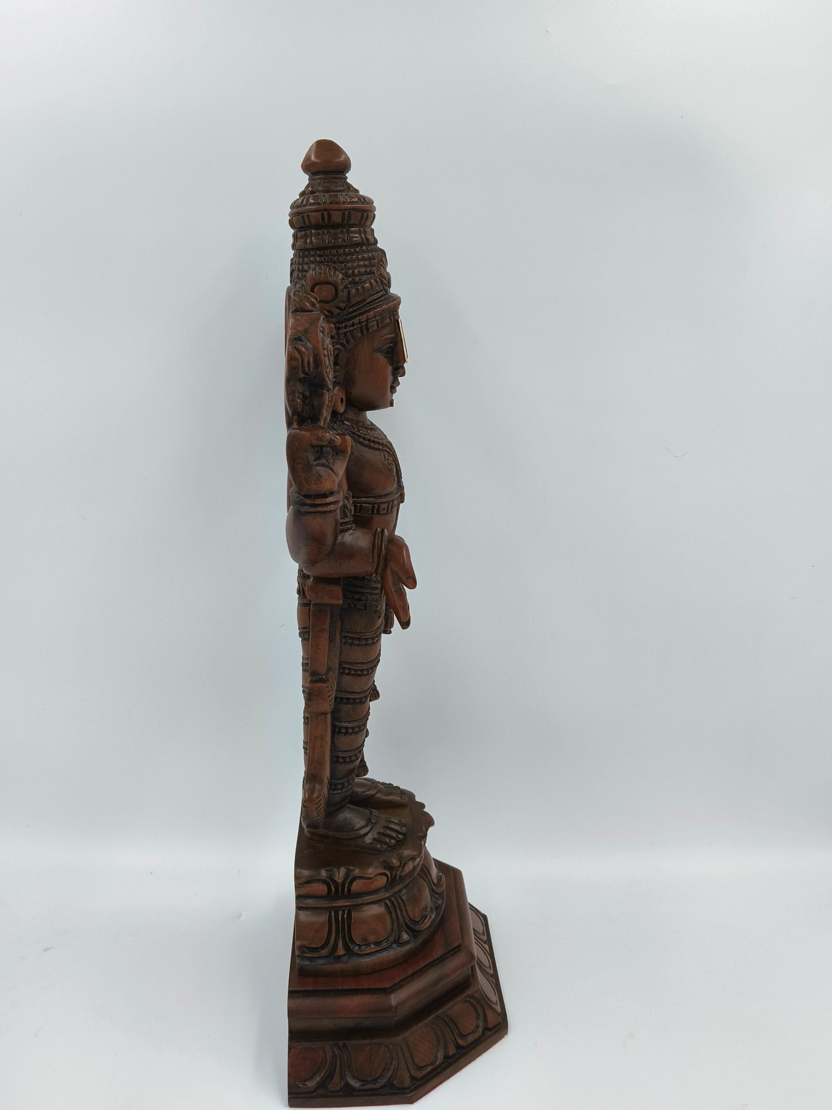Side view of large teakwood Balaji statue with detailed carvings