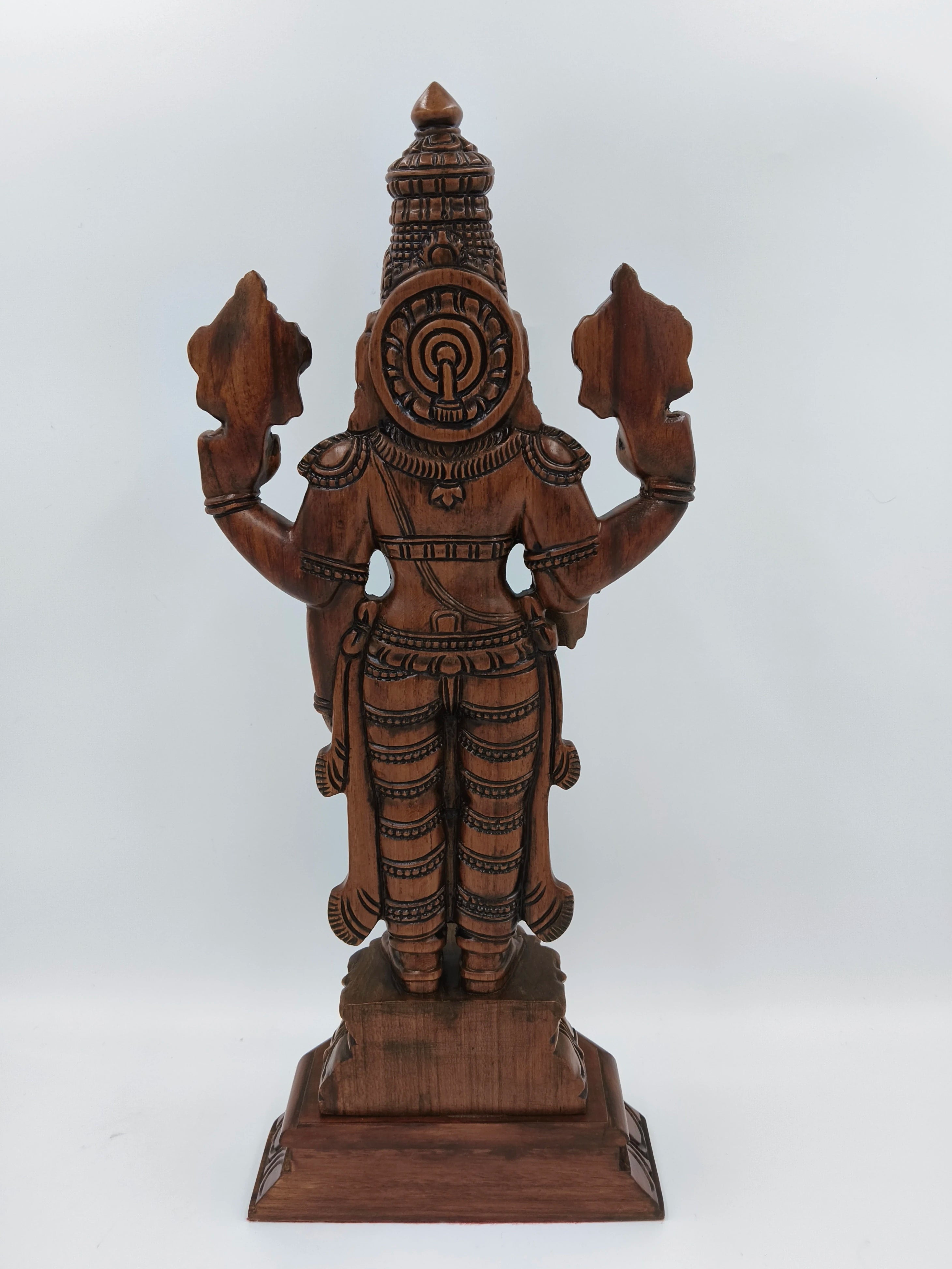 Back view of large teakwood Balaji statue with intricate carvings on pedestal