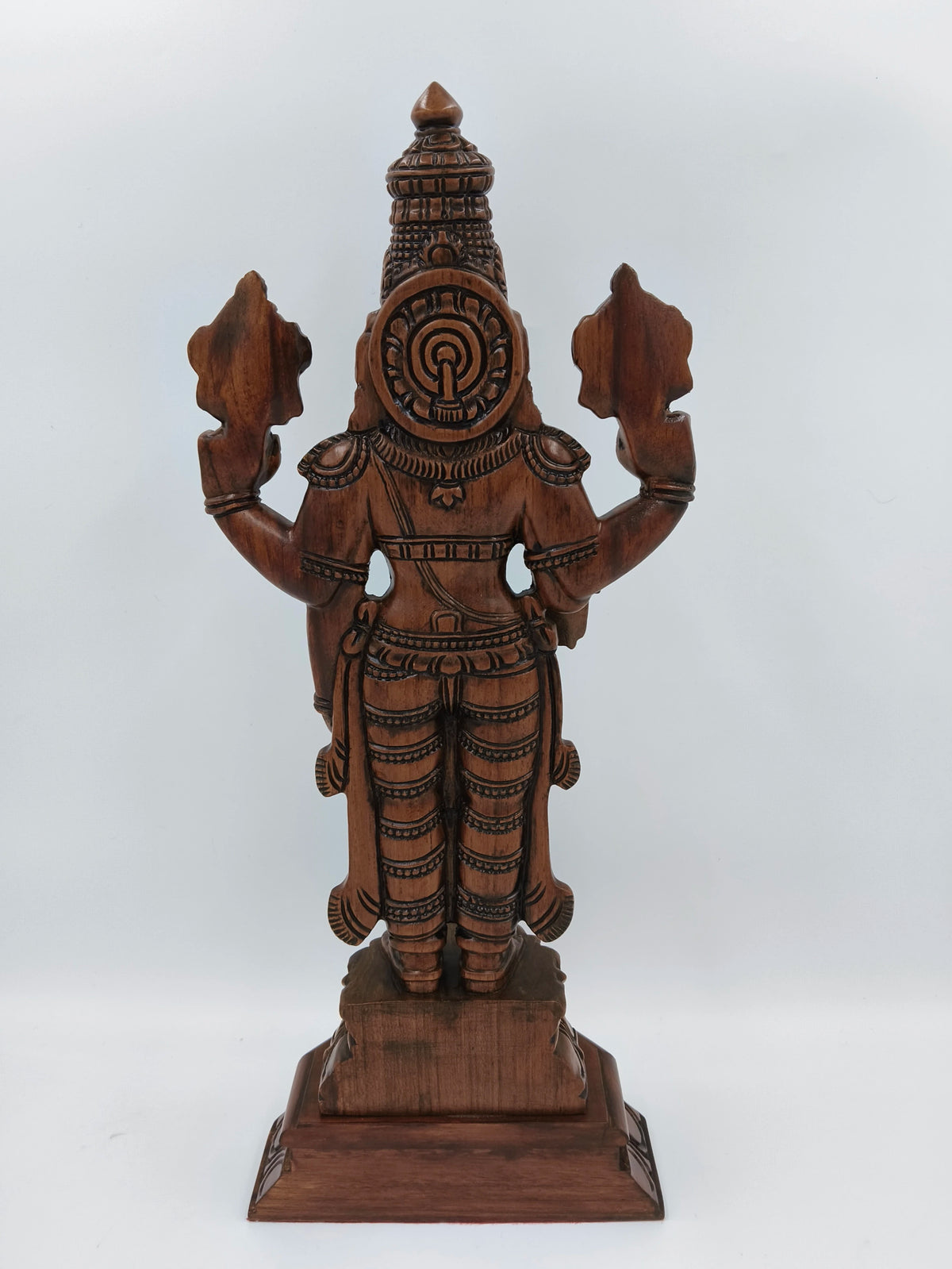 Back view of large teakwood Balaji statue with intricate carvings on pedestal