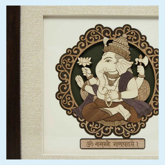 Small wooden art picture of Ganesh with intricate frame and Sanskrit inscription