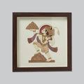 Wooden framed art piece depicting Hanuman carrying mountains in traditional style