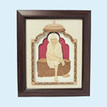 Framed wood art picture of Shirdi Baba sitting under decorative arch