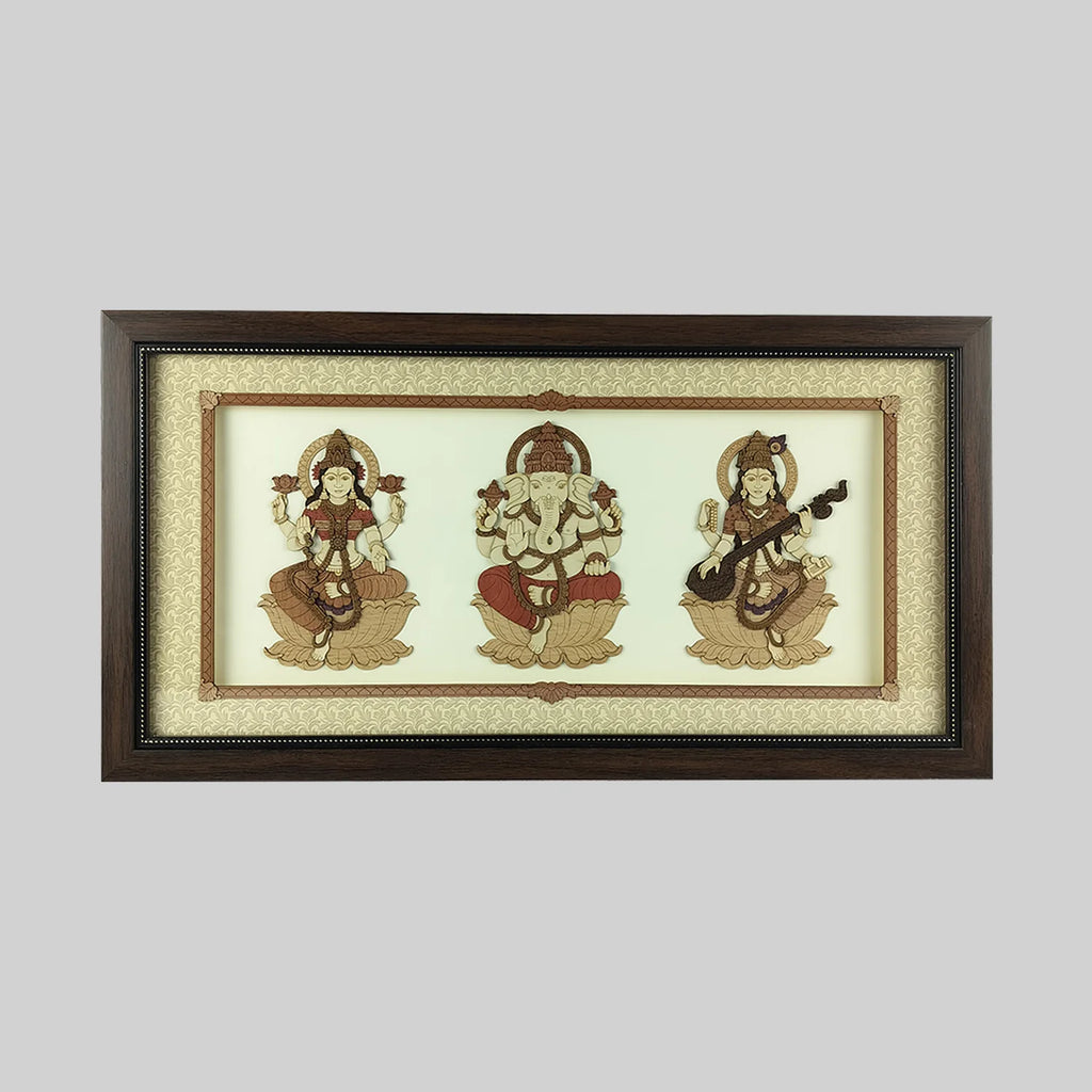 Wood art frame featuring seated Lakshmi, Ganesh, and Saraswathi deities