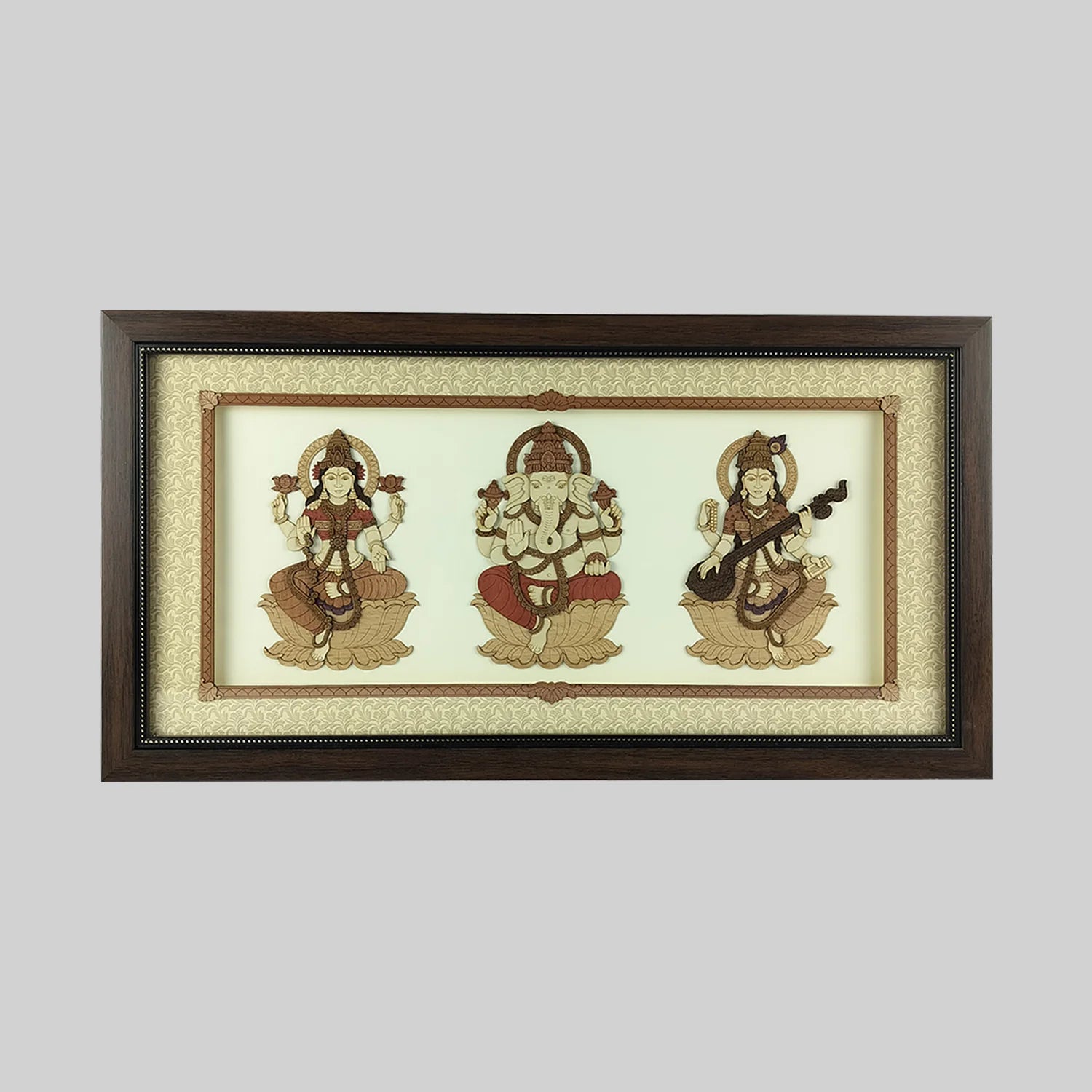 Wood art frame featuring seated Lakshmi, Ganesh, and Saraswathi deities