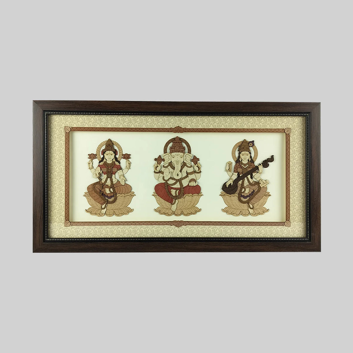 Wood art frame featuring seated Lakshmi, Ganesh, and Saraswathi deities