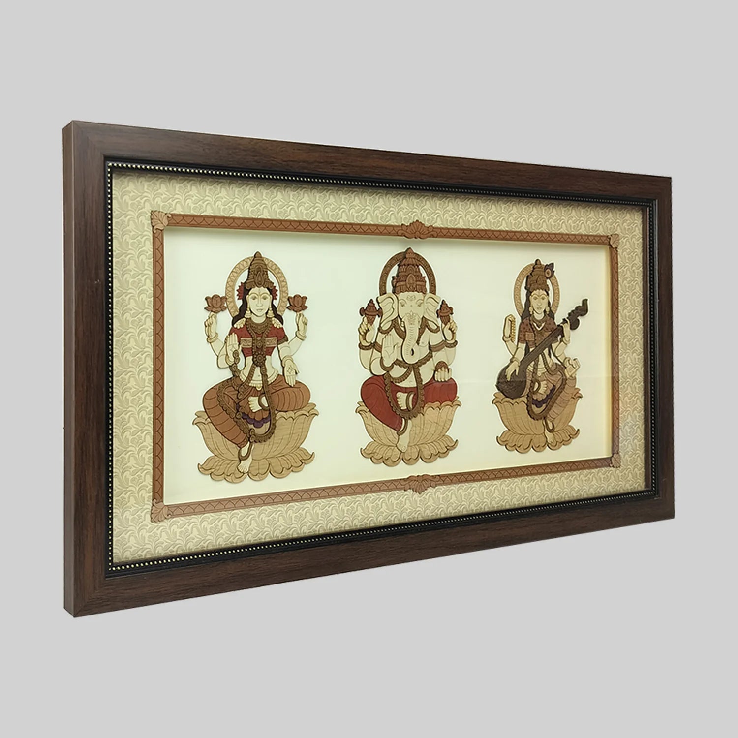 Wood art frame featuring Lakshmi, Ganesh, and Saraswathi deities on cream background