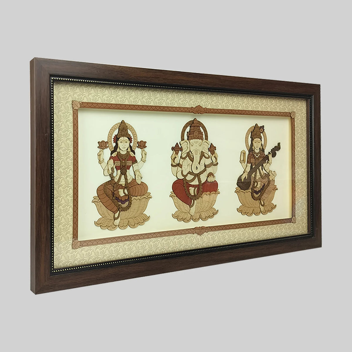 Wood art frame featuring Lakshmi, Ganesh, and Saraswathi deities on cream background