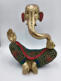 Large brass Ganesha statue seated with colorful patterned clothing details