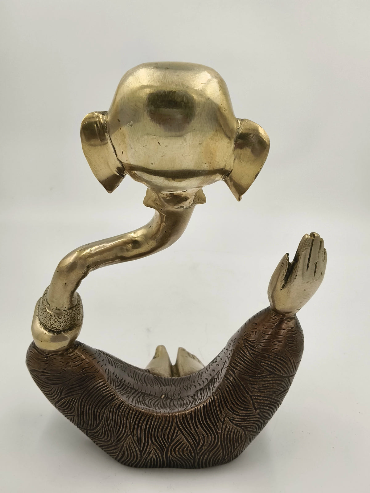 Modern brass Ganesha statue seated, side view with detailed texture