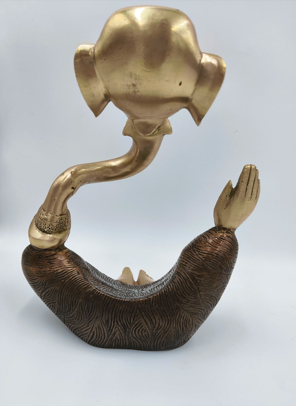 Brass modern Ganesha statue with textured base and curved trunk, rear view