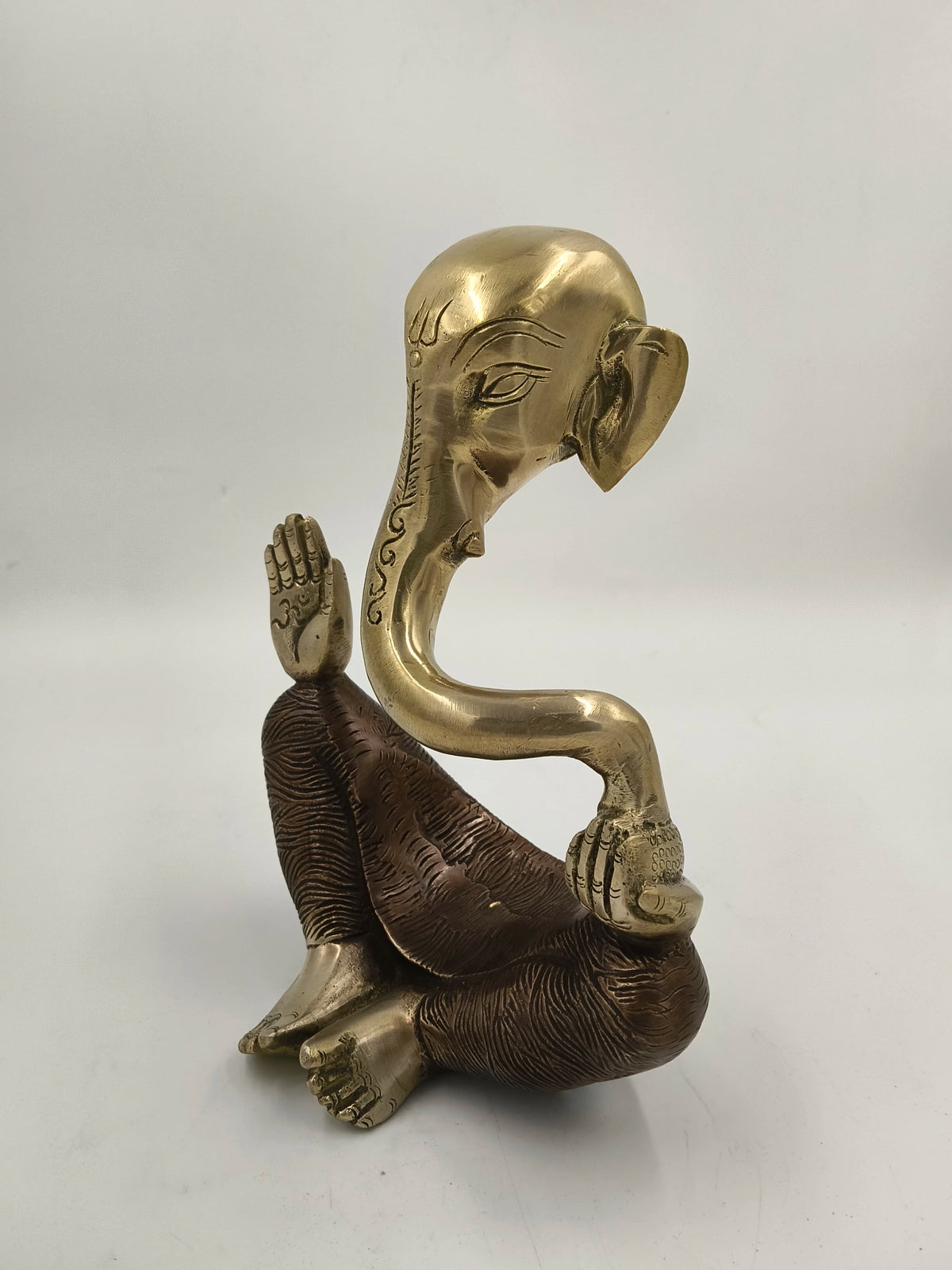 Brass modern Ganesha statue with textured base and curved trunk, rear view