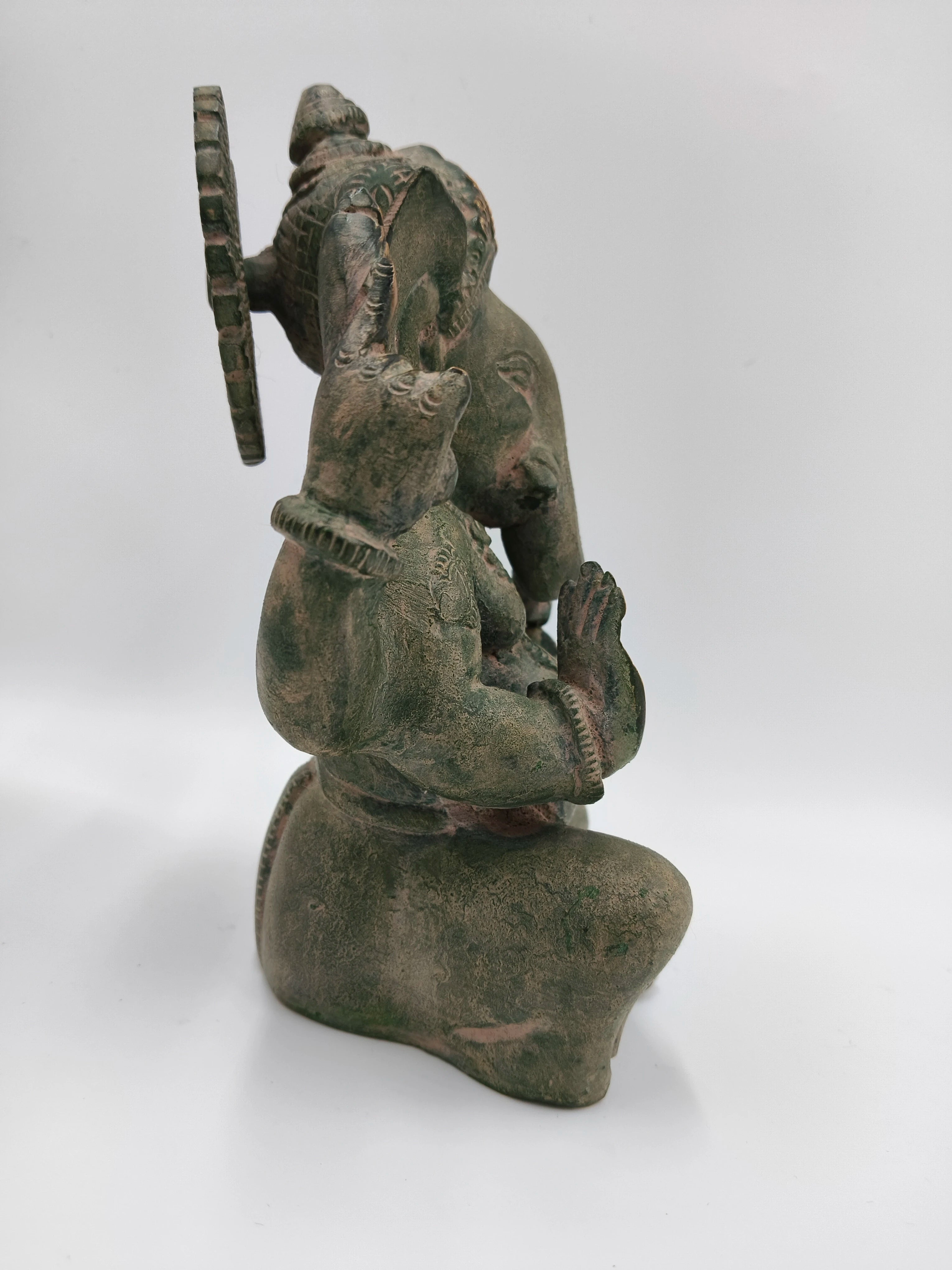 Side view of a brass Appu Ganesha statue with detailed craftsmanship