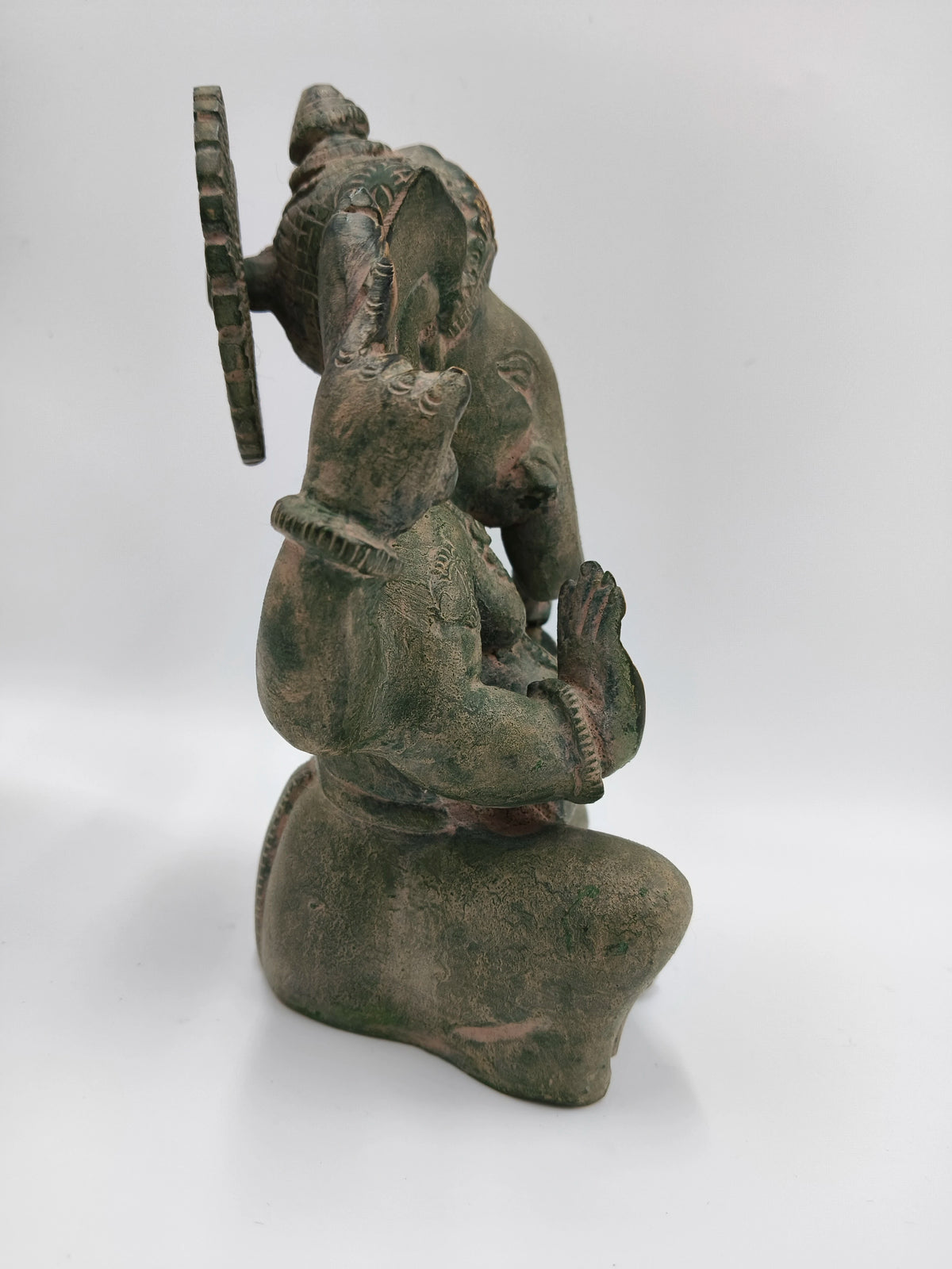Side view of a brass Appu Ganesha statue with detailed craftsmanship