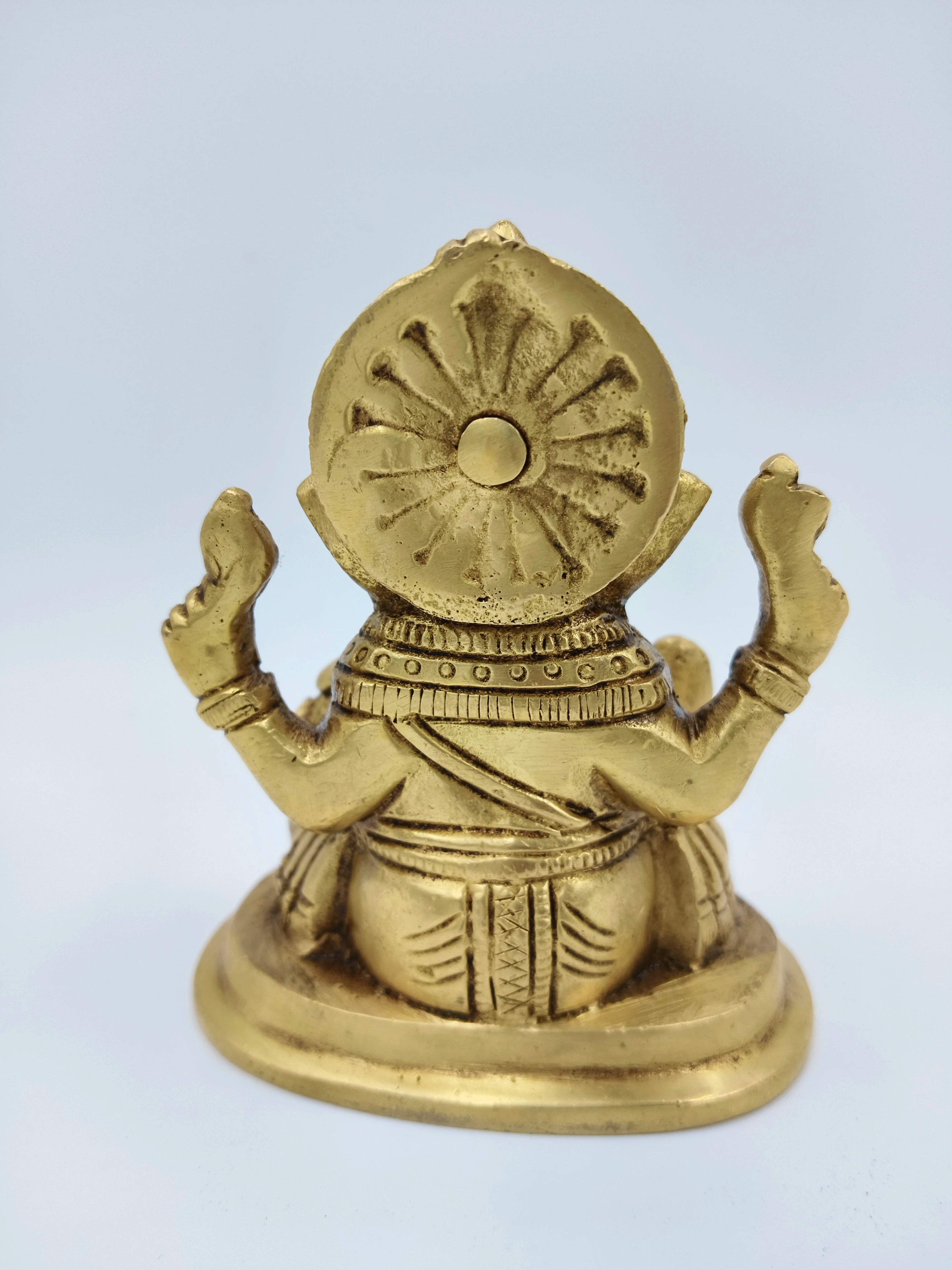 Back view of small brass Ganesha statue seated on base