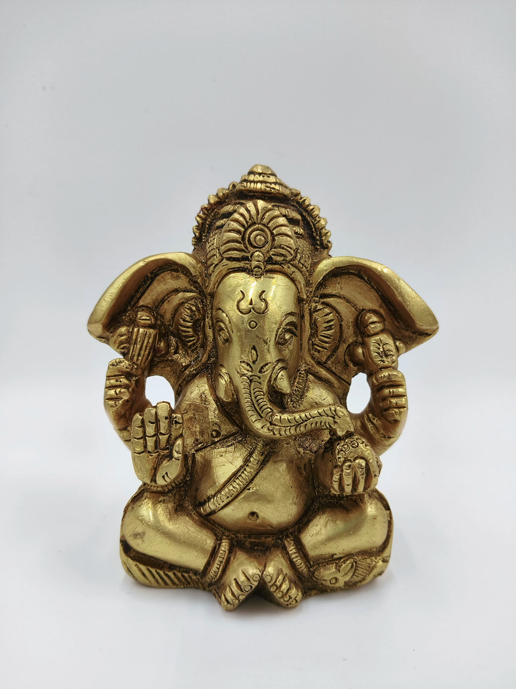 Small brass statue of Ganesh seated with detailed craftsmanship