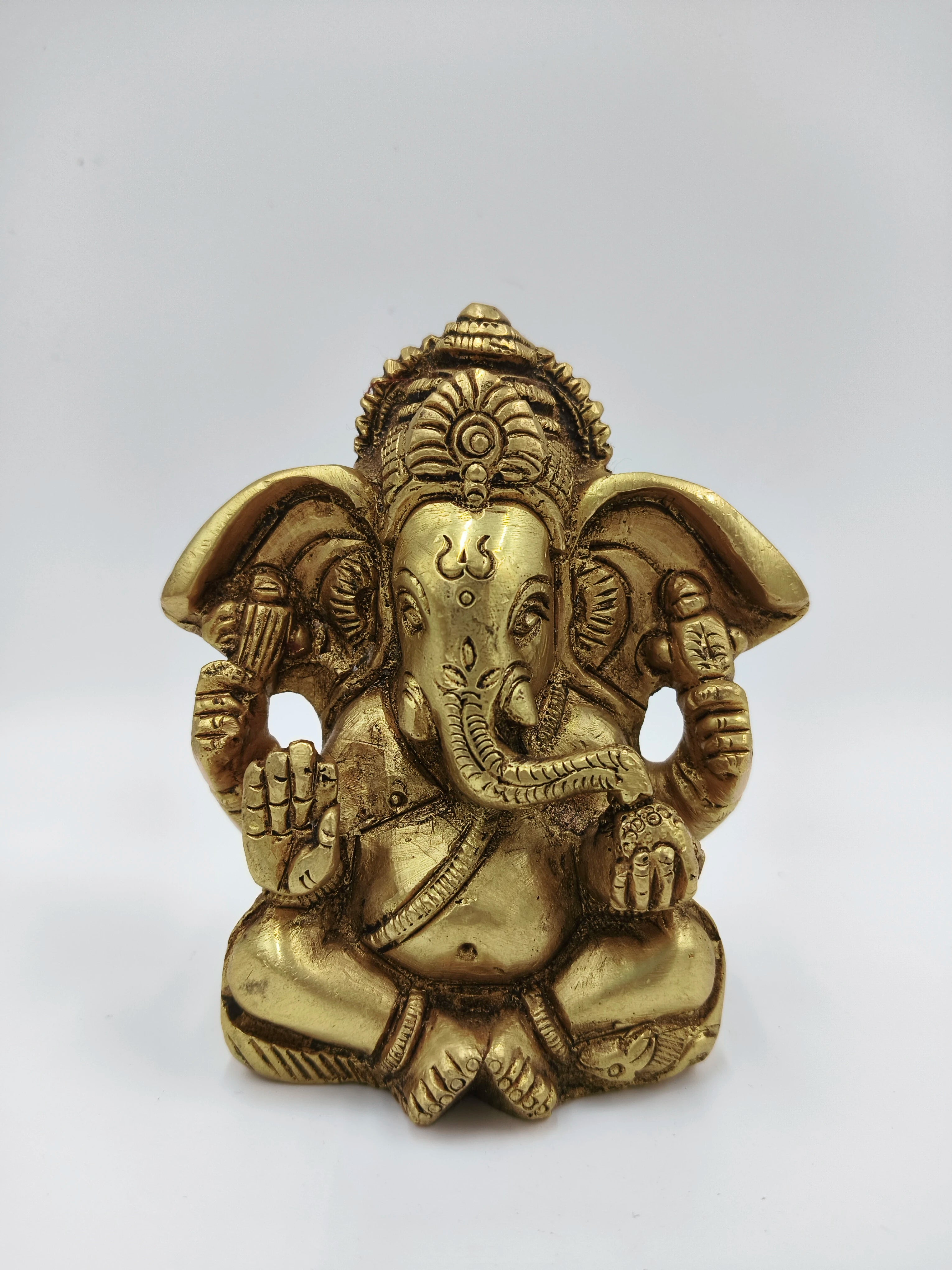 Small brass statue of Ganesh seated with detailed craftsmanship