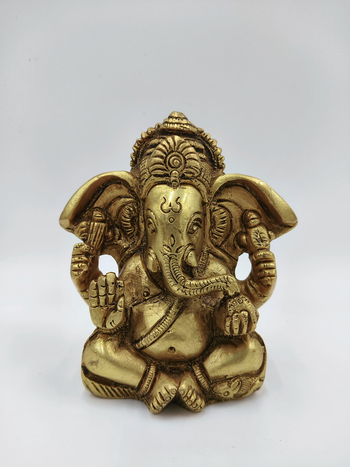 Small brass statue of Ganesh seated with detailed craftsmanship