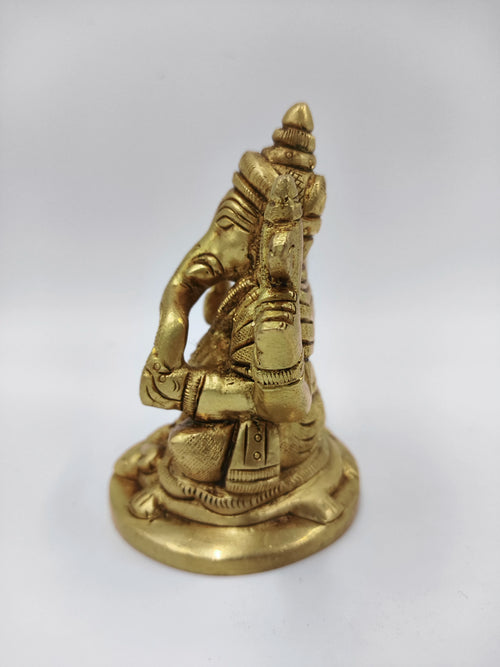 Small brass statue of sitting Lord Ganesha with detailed carvings, side view