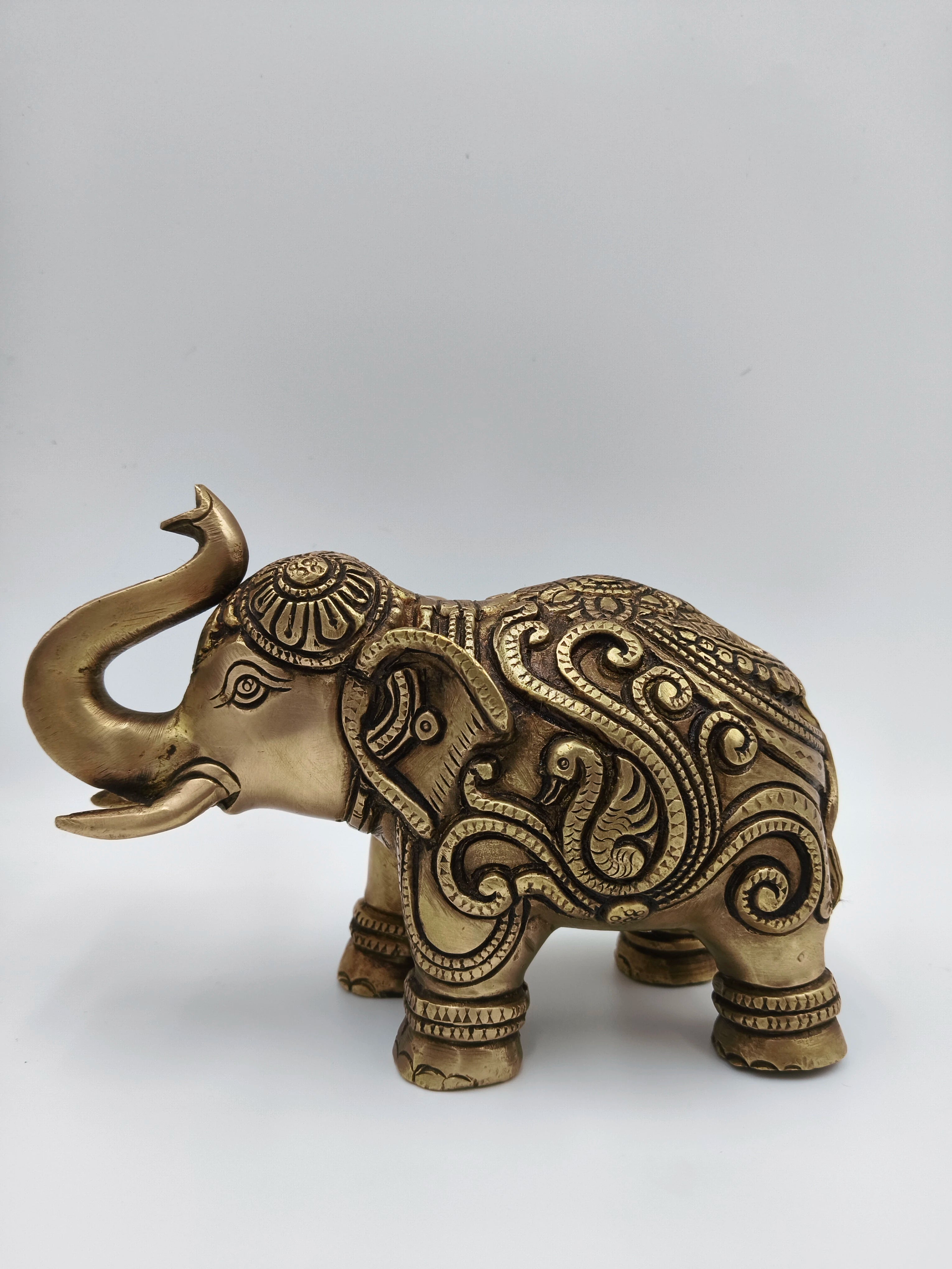 Medium-sized brass elephant figurine with intricate carving detail side view