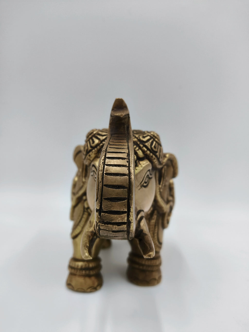 Front view of medium-sized brass elephant figurine with decorative carvings